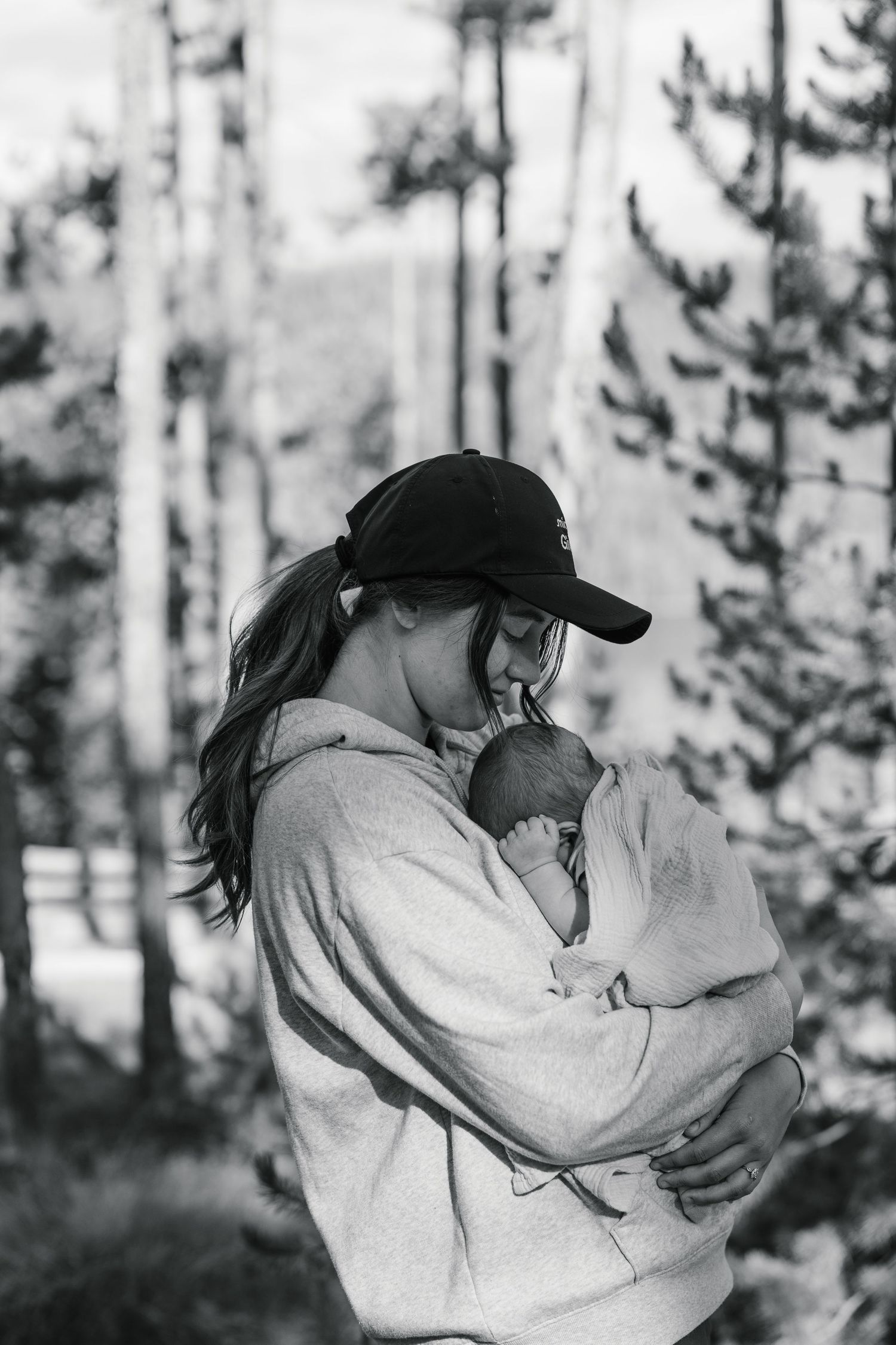 Heartfelt Des Moines family photography: new mom cradling newborn baby in warm glow, real connection moment