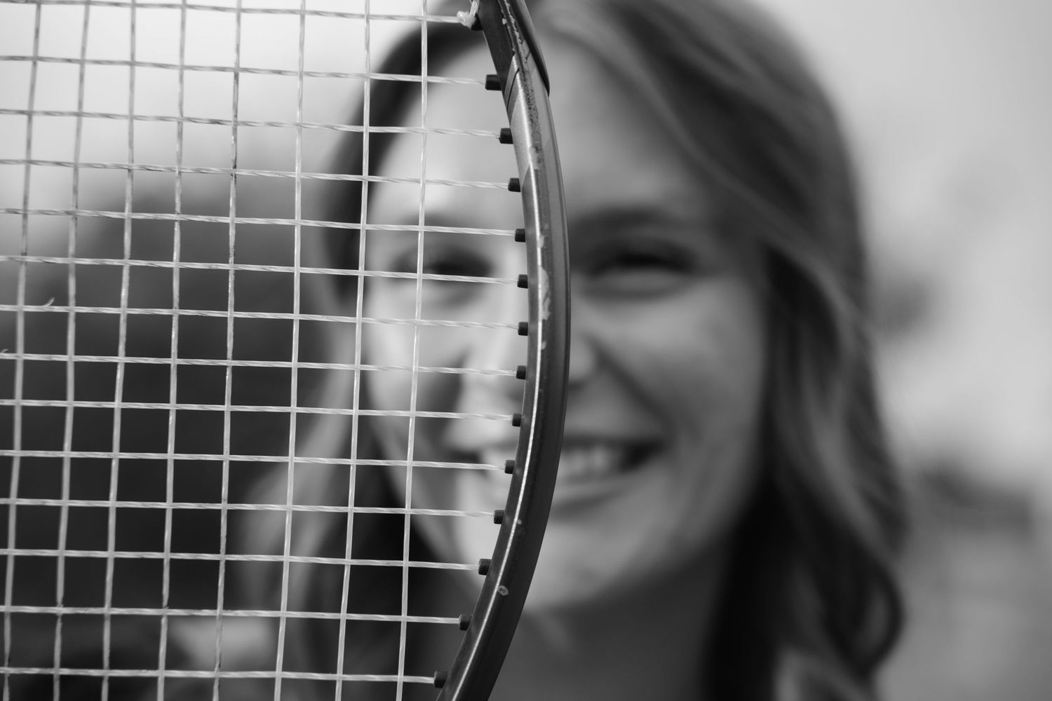 Des Moines Iowa senior portrait photographer – happy teenage girl posing with tennis racket.