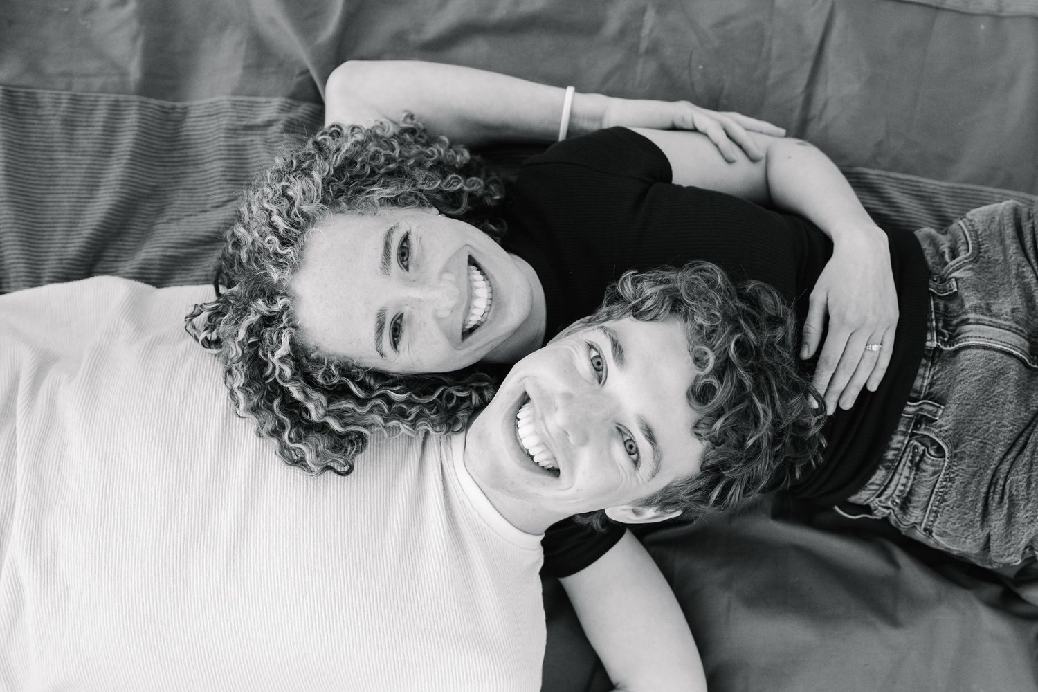 Des Moines Iowa engagement photographer – black and white intimate couple portrait lying on blanket, relaxed and joyful moment