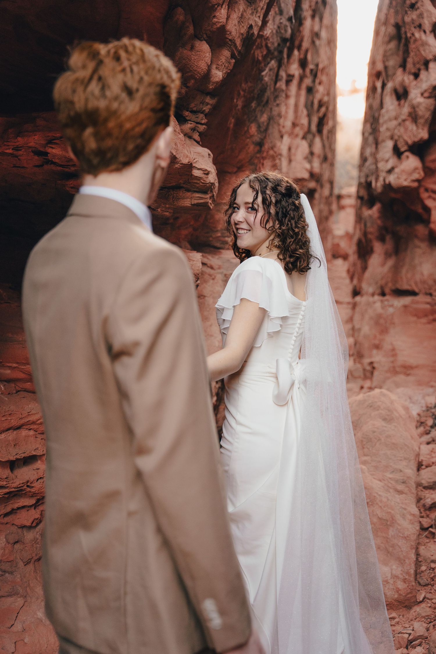 Des Moines destination wedding photographer – bride and groom in red rock canyon, romantic portrait with dramatic desert landscape.