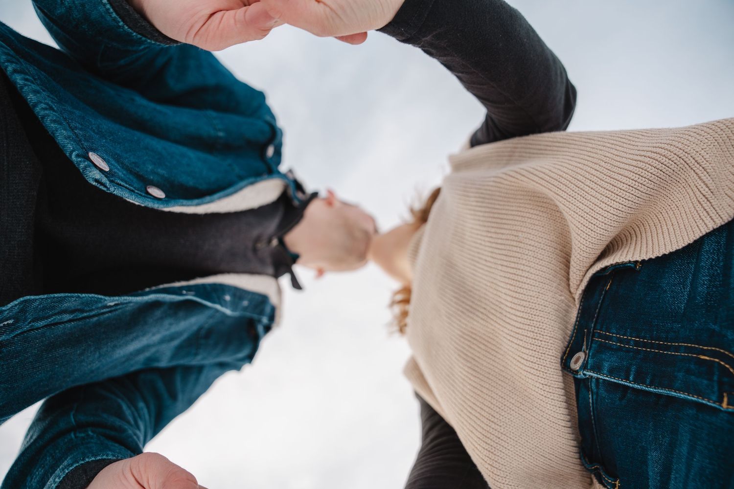 Des Moines Iowa winter engagement photographer – groom kissing bride's forehead in close-up, tender and cozy winter moment