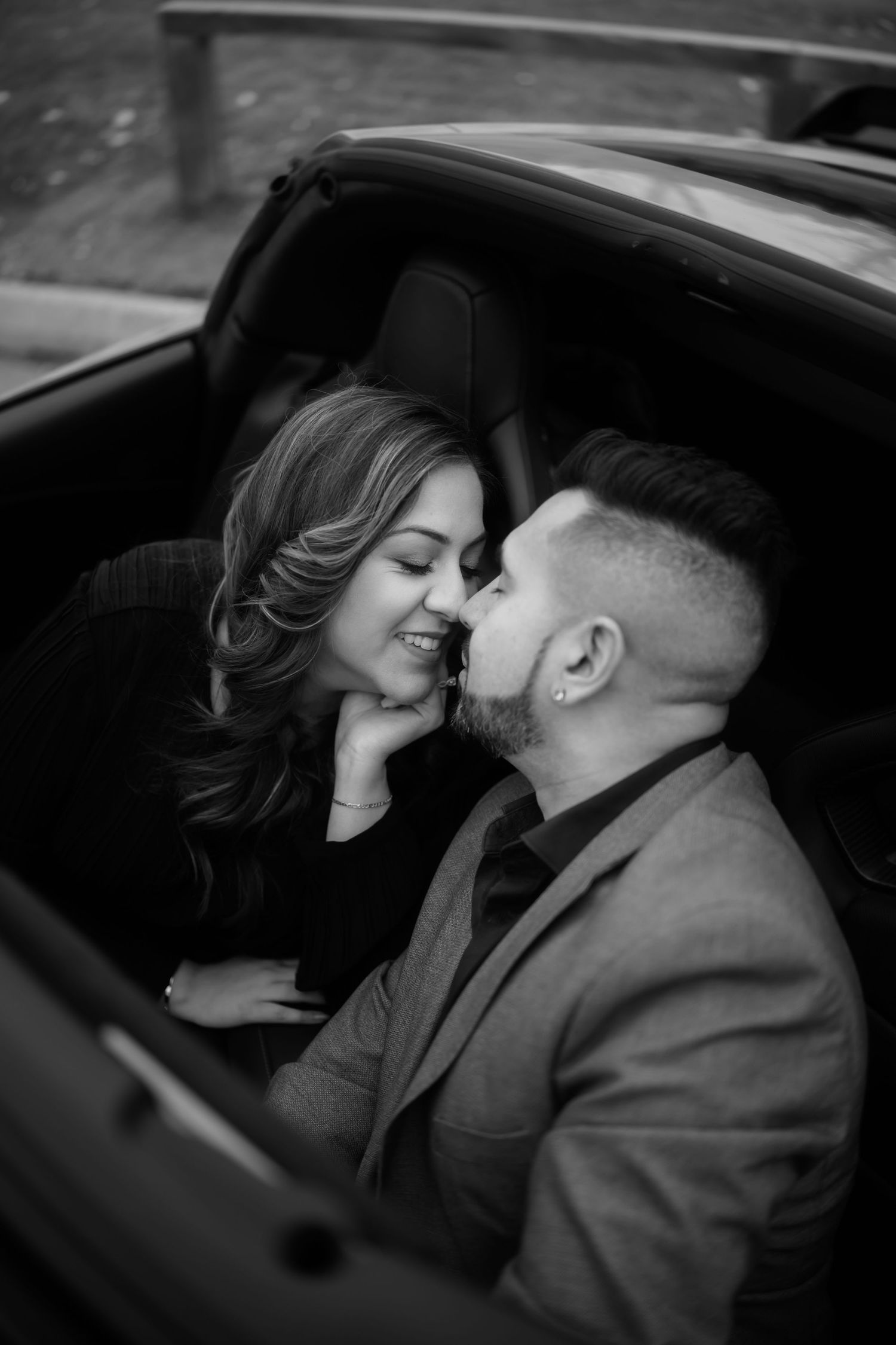 An intimate black and white moment captured of a couple in a car.