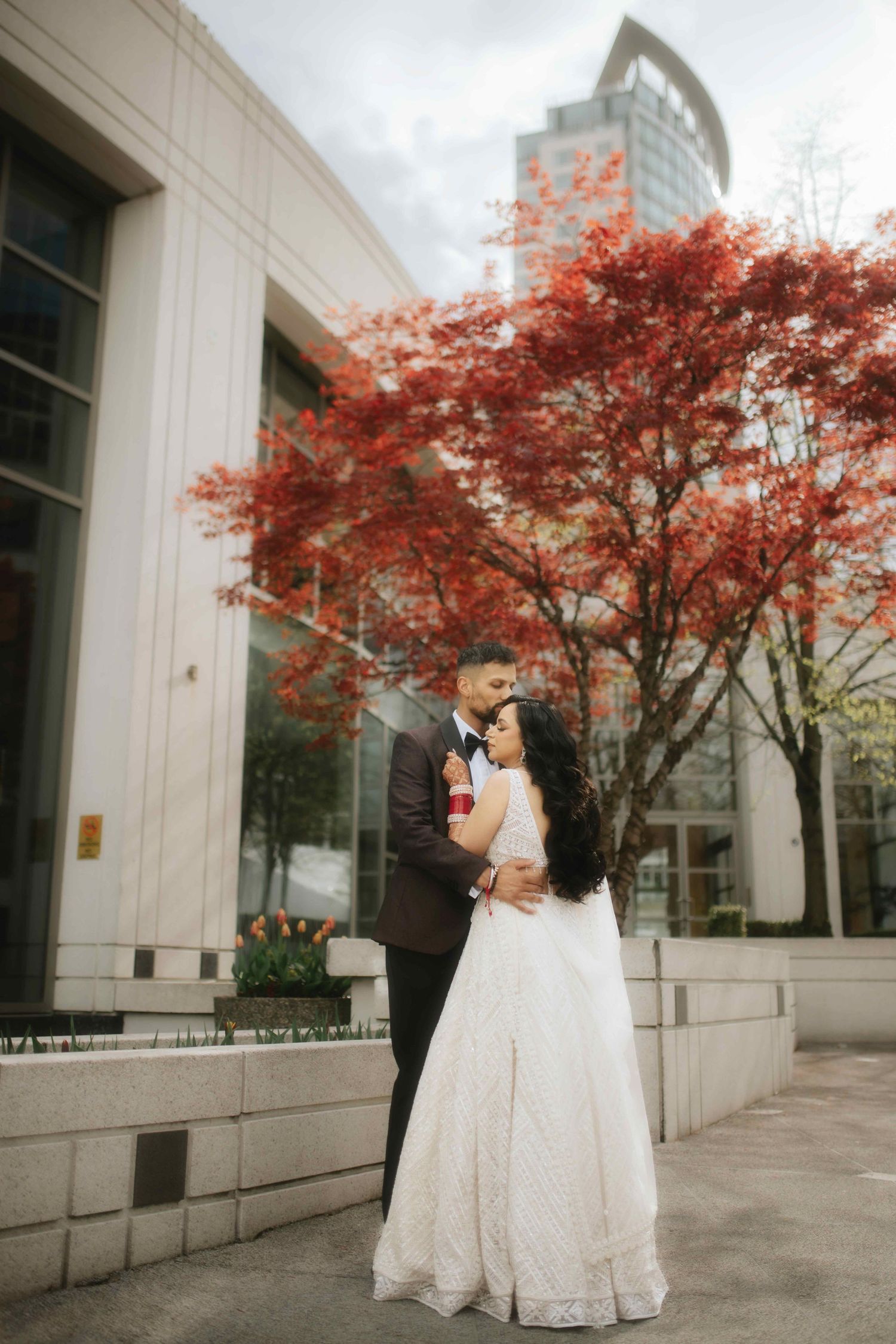 A wedding portrait against modern architecture with beautiful red maple trees.
Vancouver Reception photography