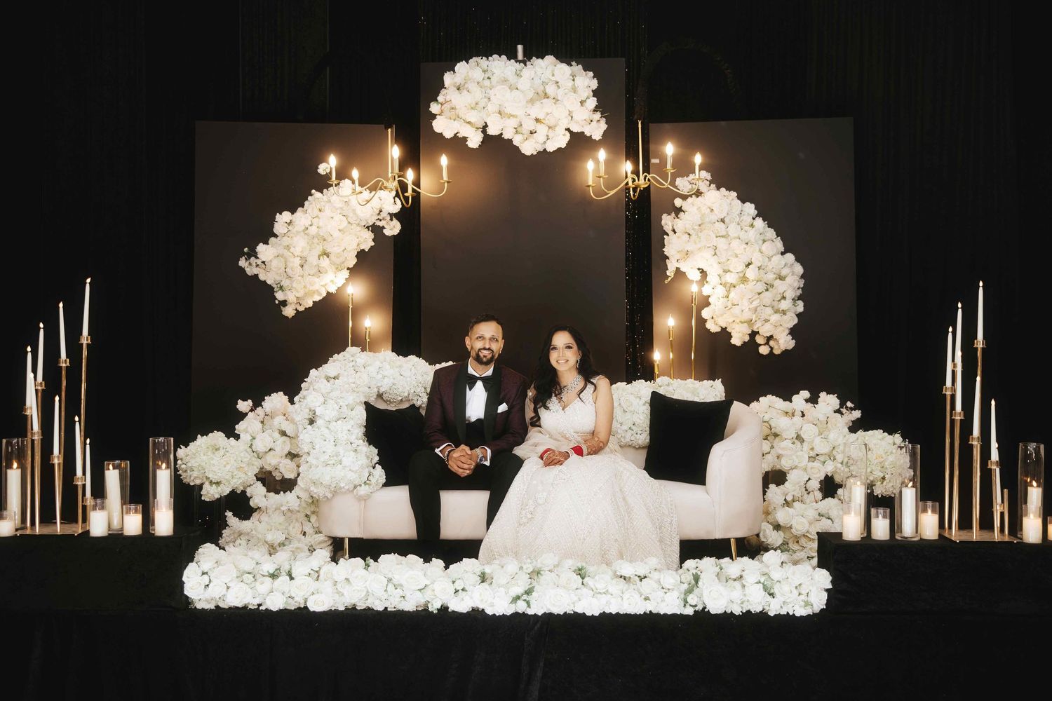 An elegant wedding reception setup with white floral arrangements and glowing candles on a dark backdrop.
Reception photography