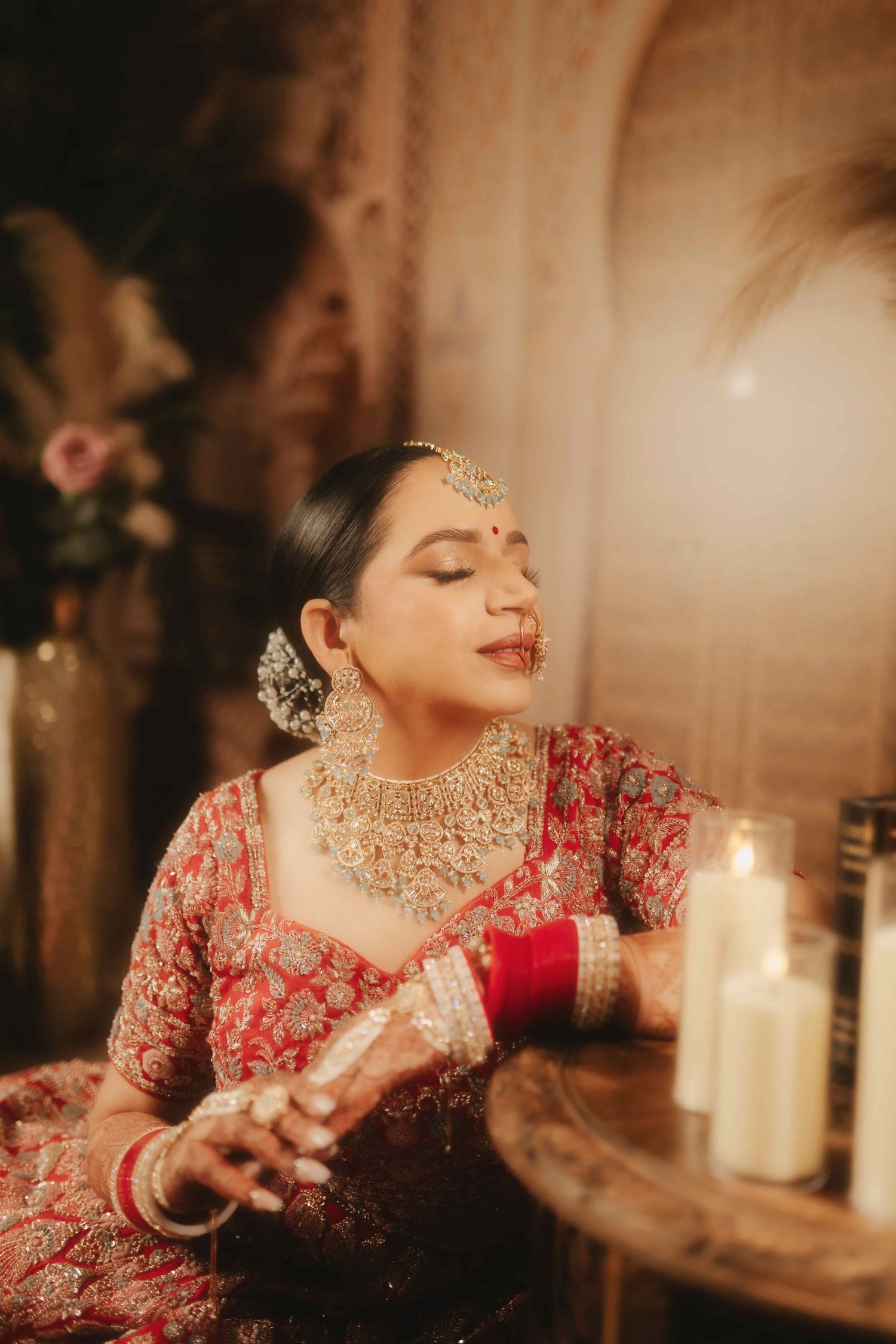Bride in traditional red Indian attire and gold jewelry poses with candlelight in warm ambient setting.
Vancouver Wedding Photography