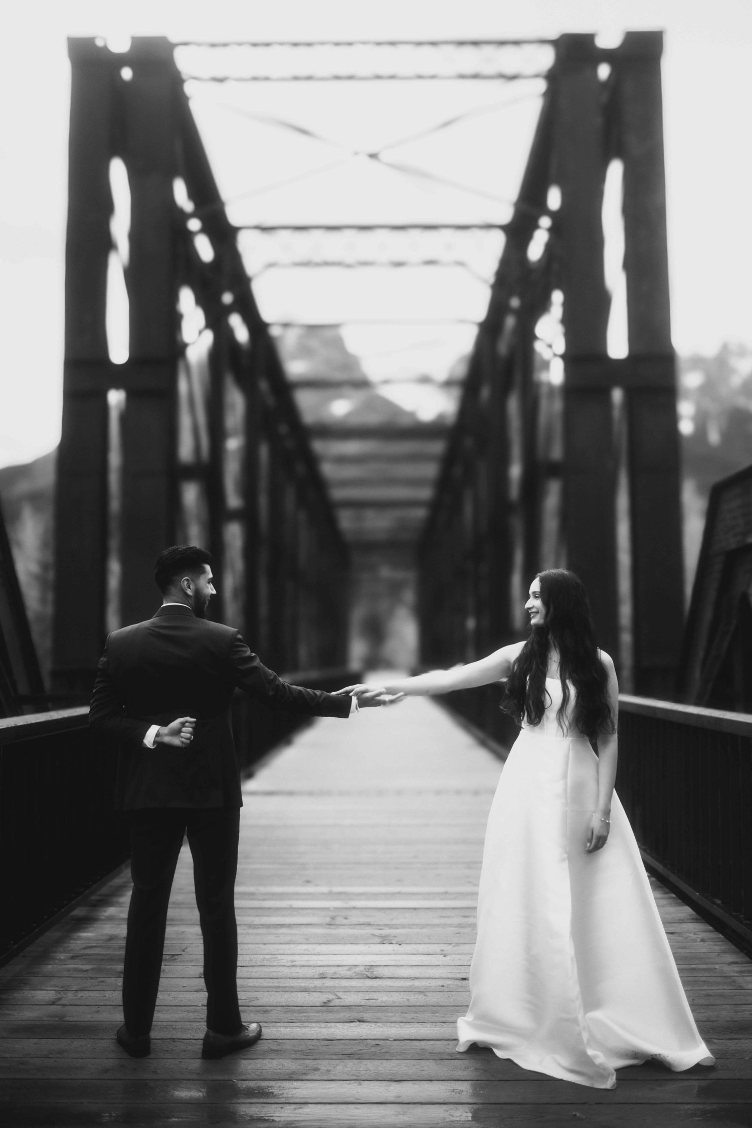 A dramatic black and white photo of a couple on a wooden bridge creating artistic silhouettes.
Black and white photography