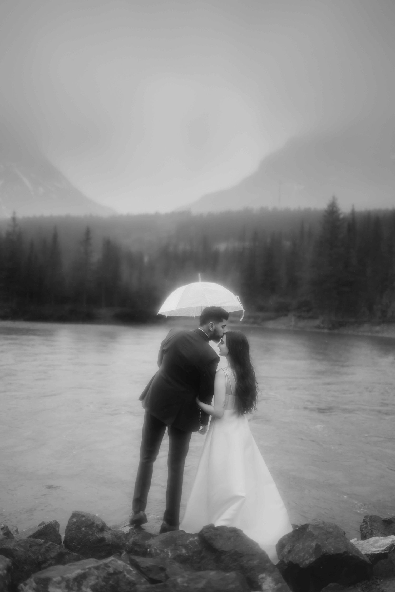 A romantic black and white photo shoot by a misty mountain lake with an umbrella.
Banff Couple Shoot
