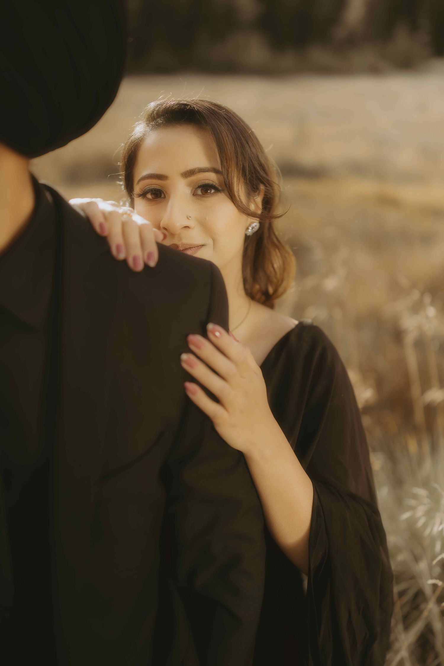 A golden-hour portrait shows a soft romantic embrace with someone wearing a loose black top in an outdoor setting.
Banff Engagement Shoot