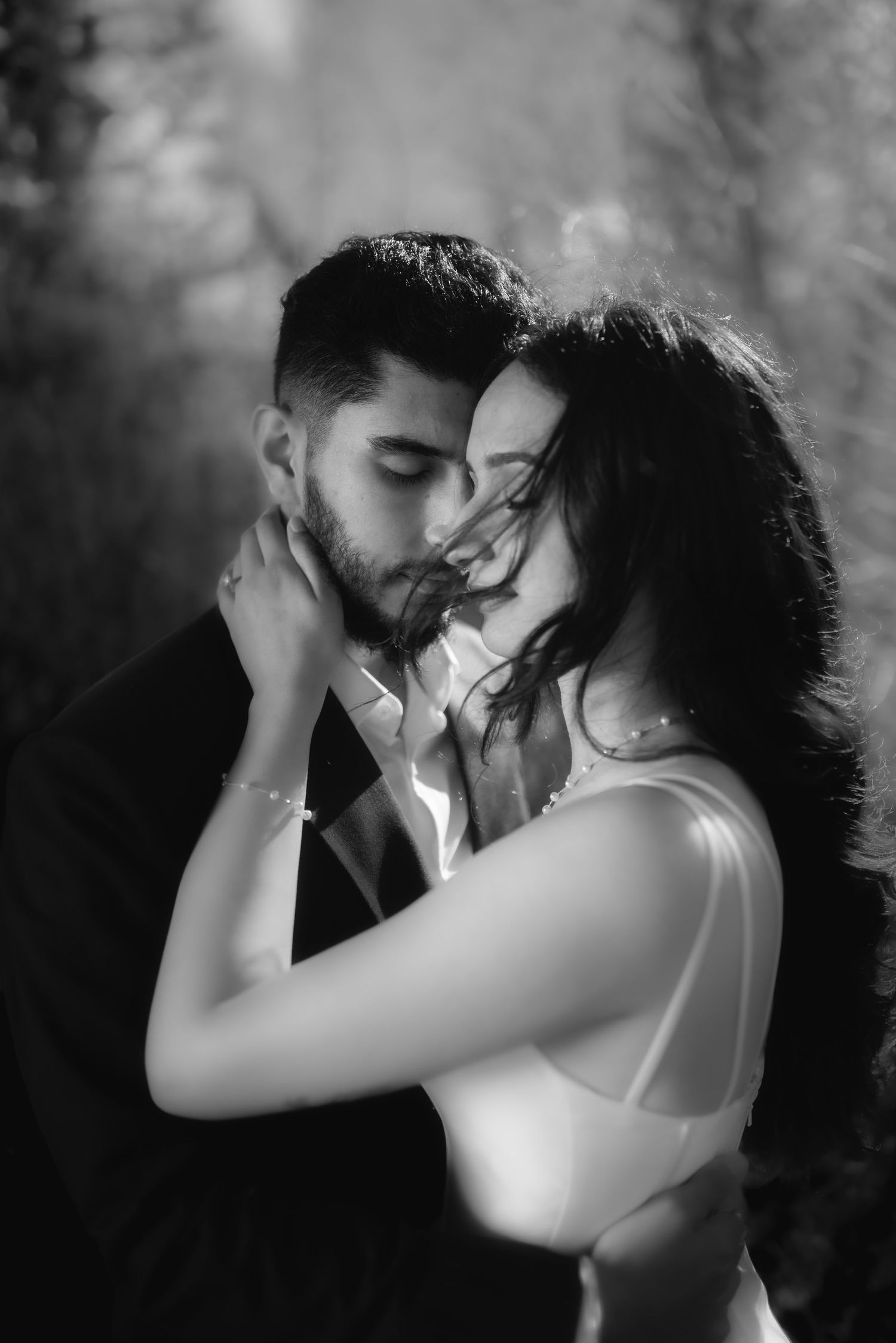 An intimate black and white portrait of a couple sharing a romantic moment.