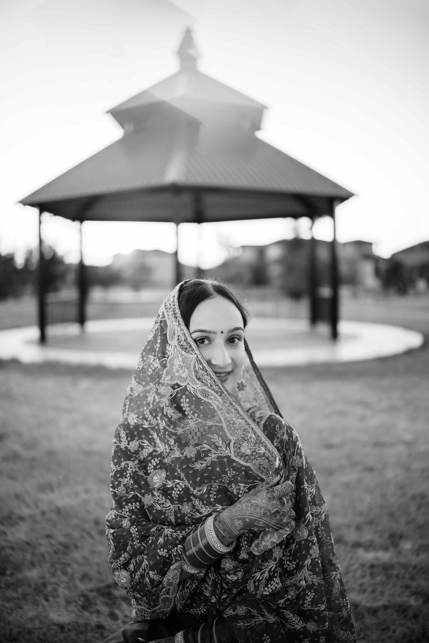 Black and white portrait with intricate dupatta against gazebo backdrop.
Punjabi Bride