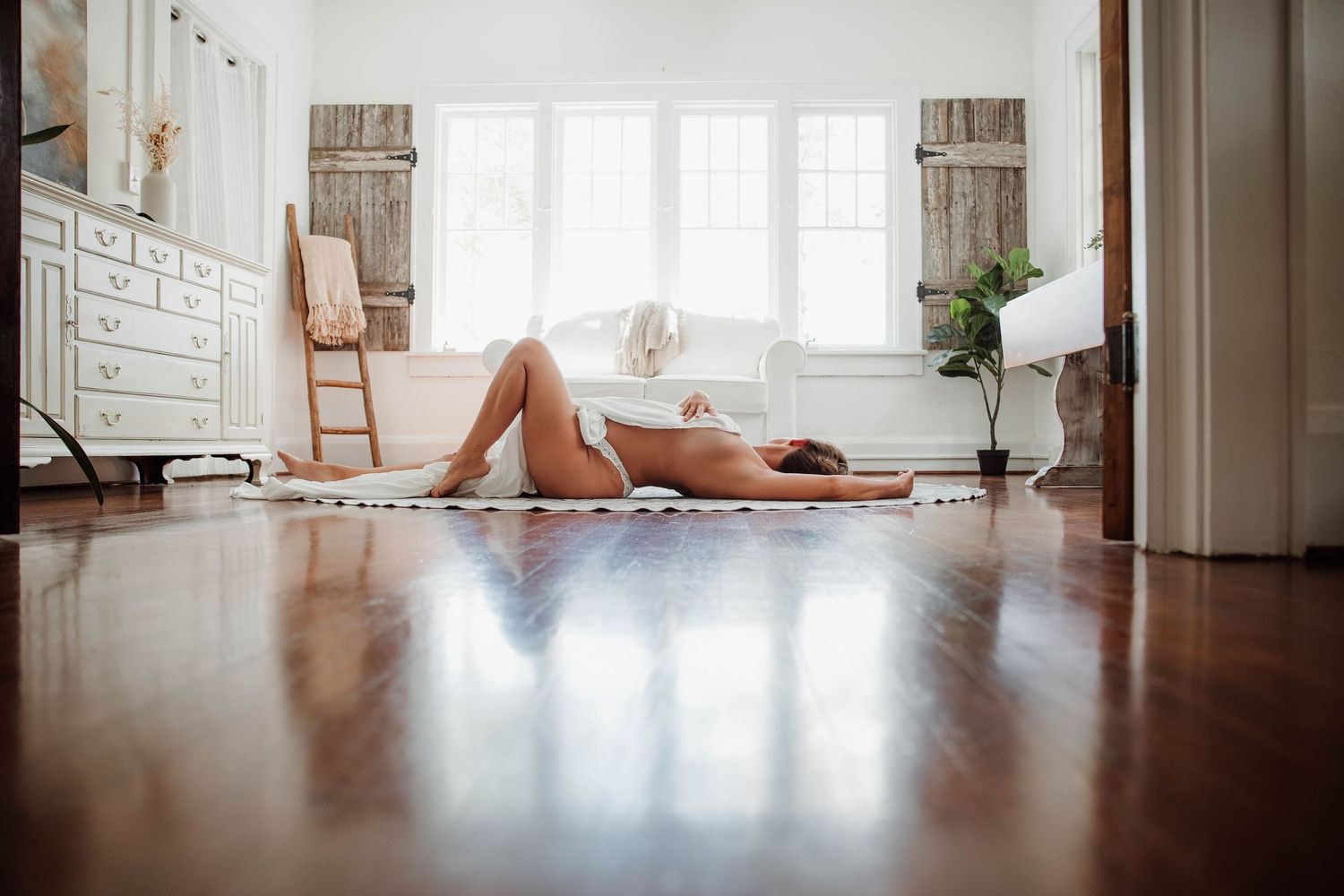 Editorial boudoir portrait of a woman reclining in a light filled Sarasota studio.