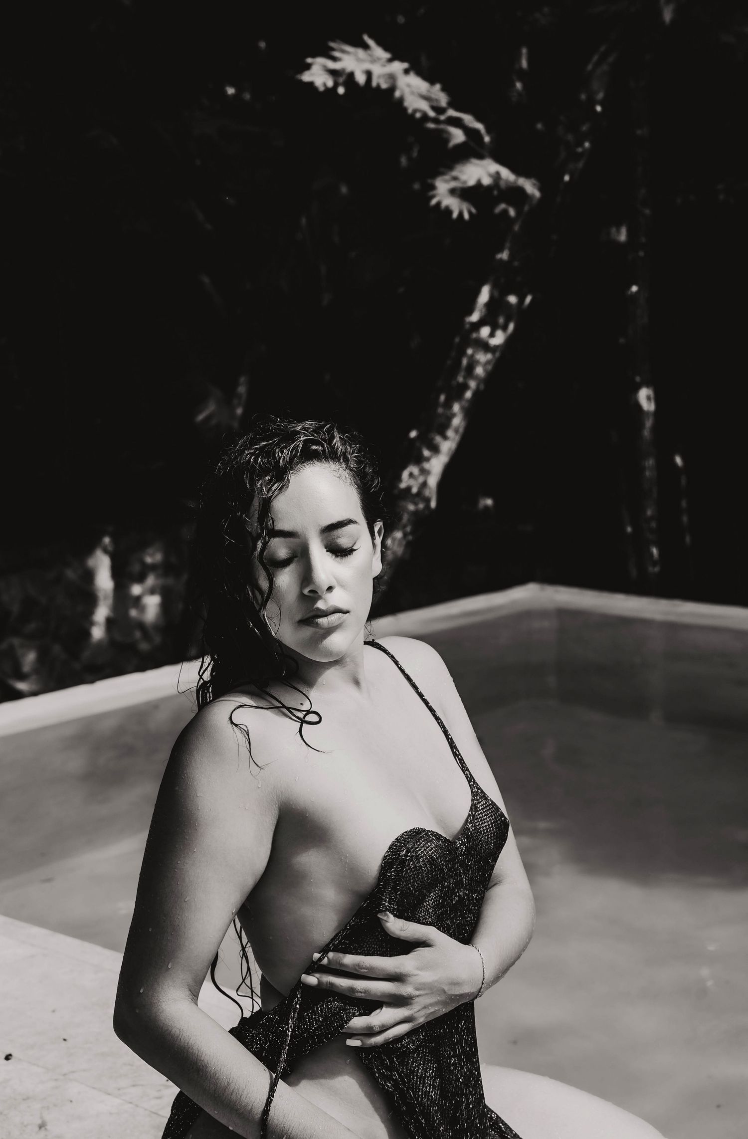 Close up of a black-and -white image of a women wearing a black dress in an boudoir session.