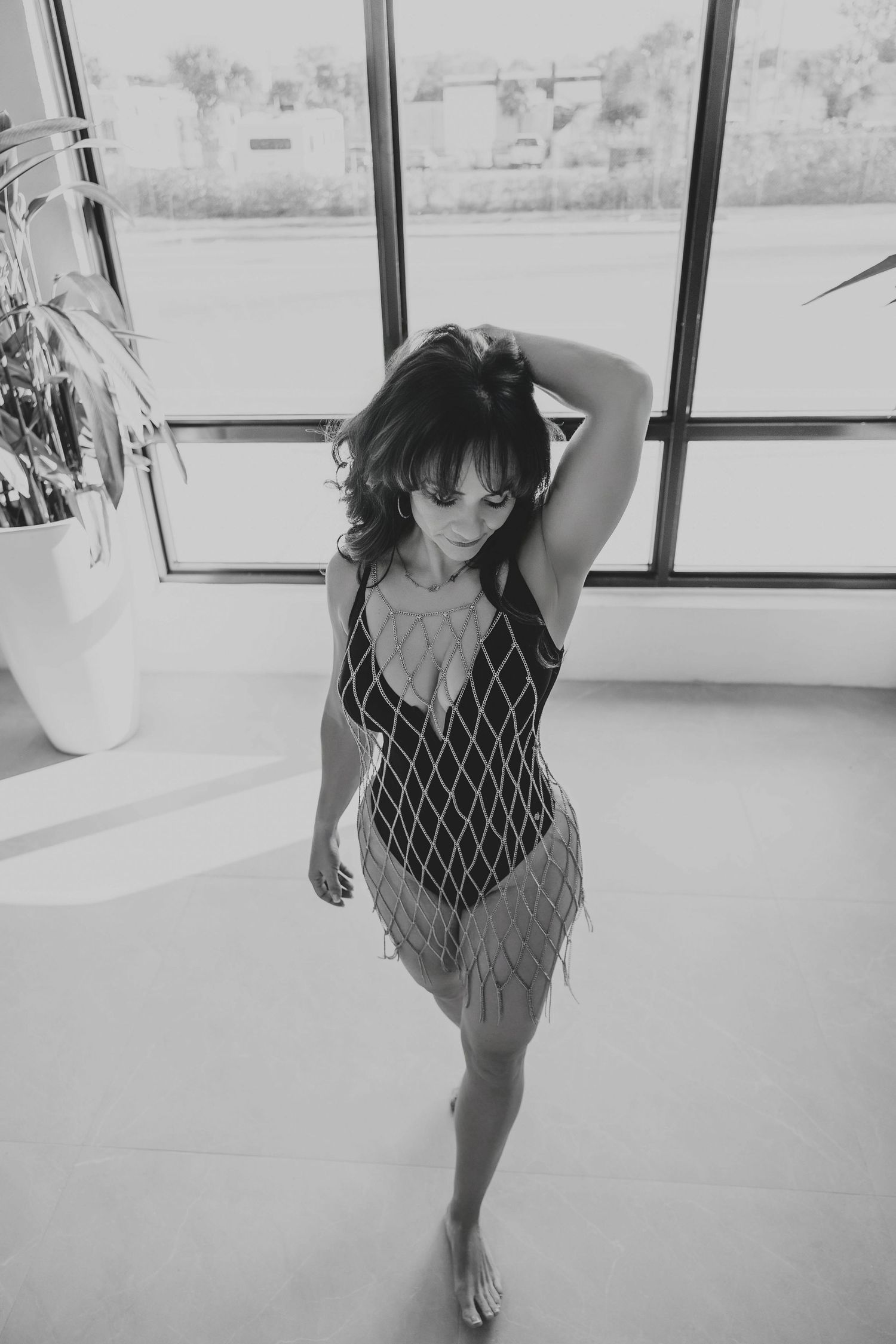Woman posing by a large window in a Sarasota Boudoir Studio