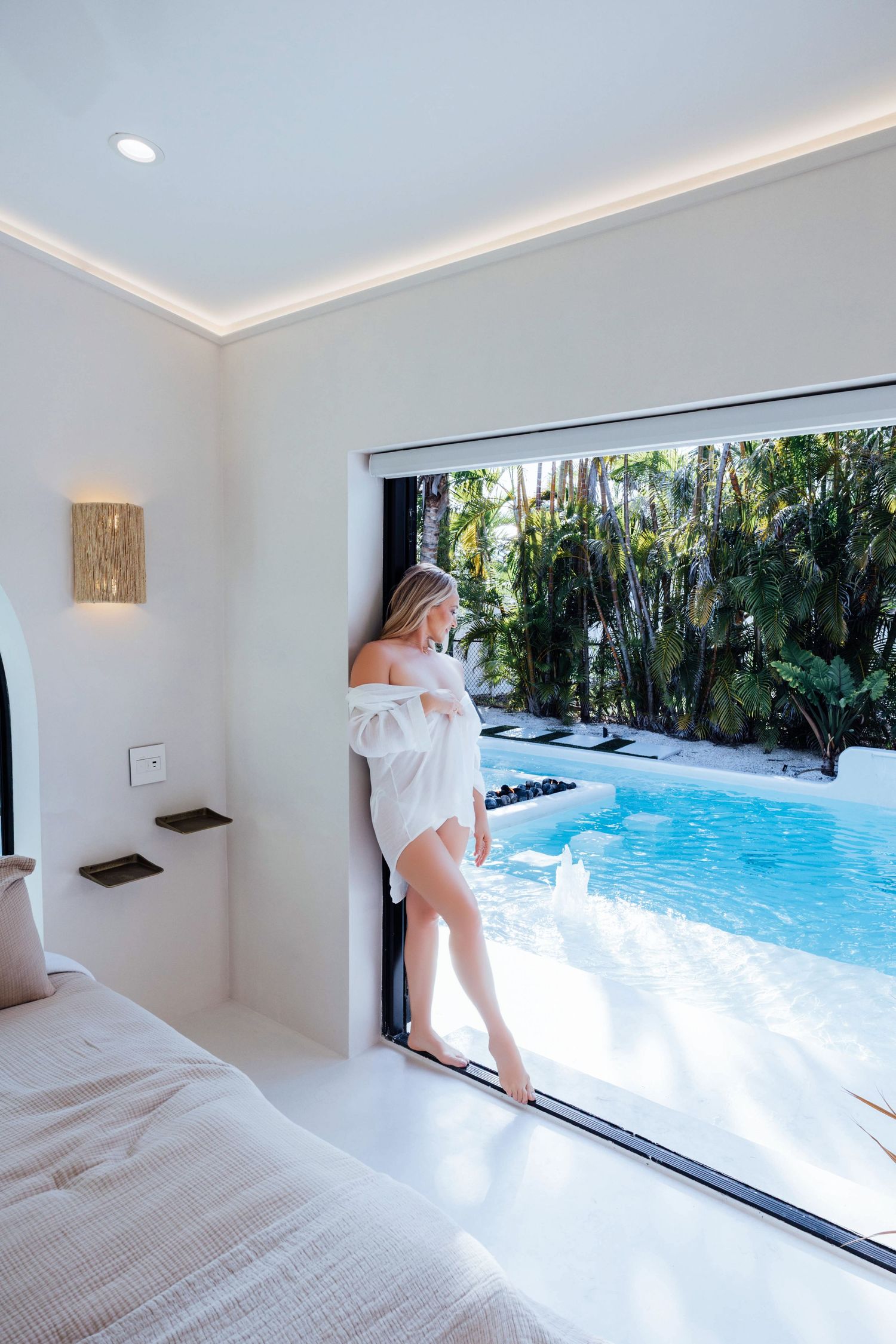 Woman standing near a pool durning her boudoir session in a modern studio