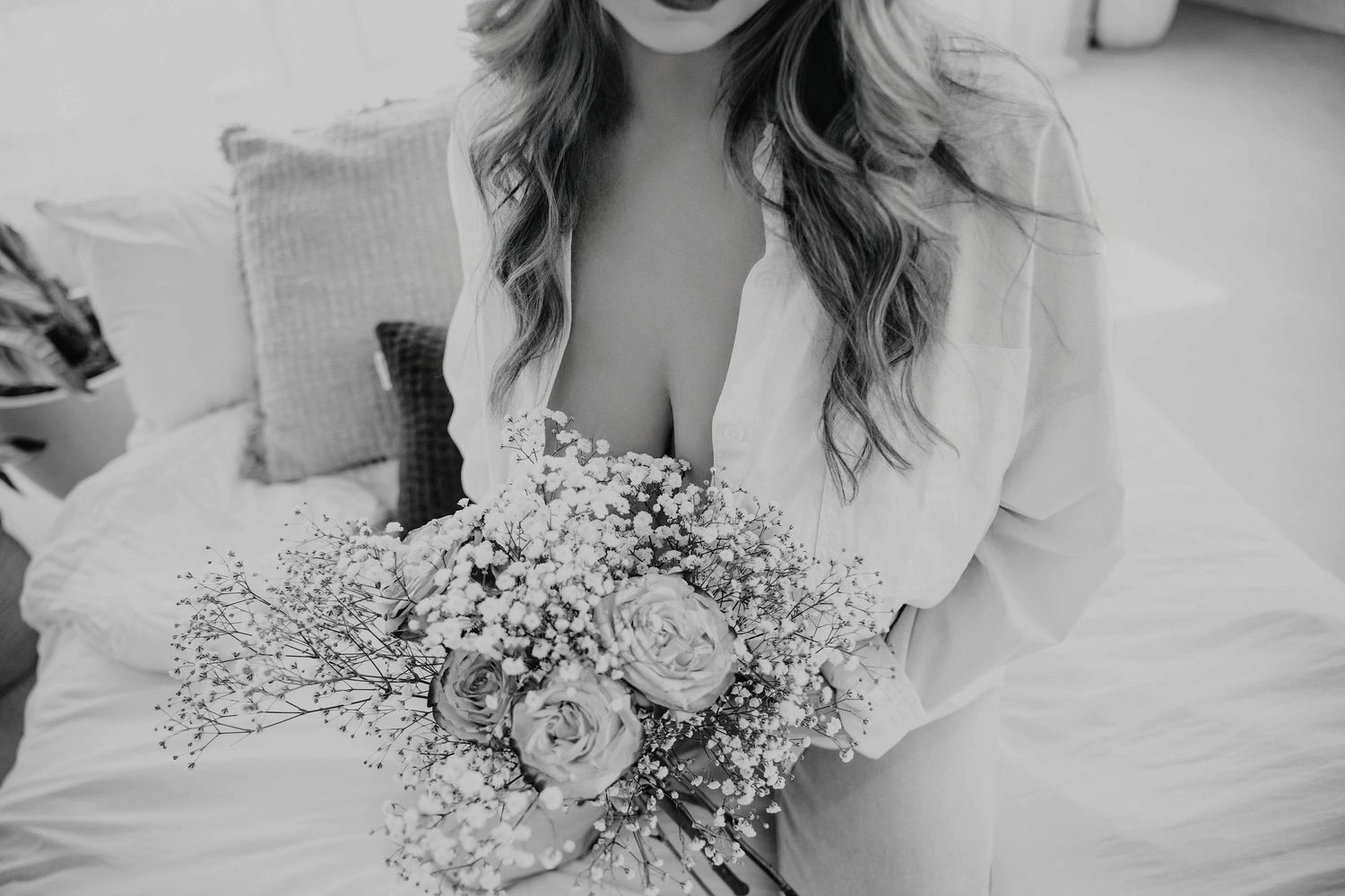 black-and-white bridal boudoir portrait of a bride holdinga dedicated flower bouquet