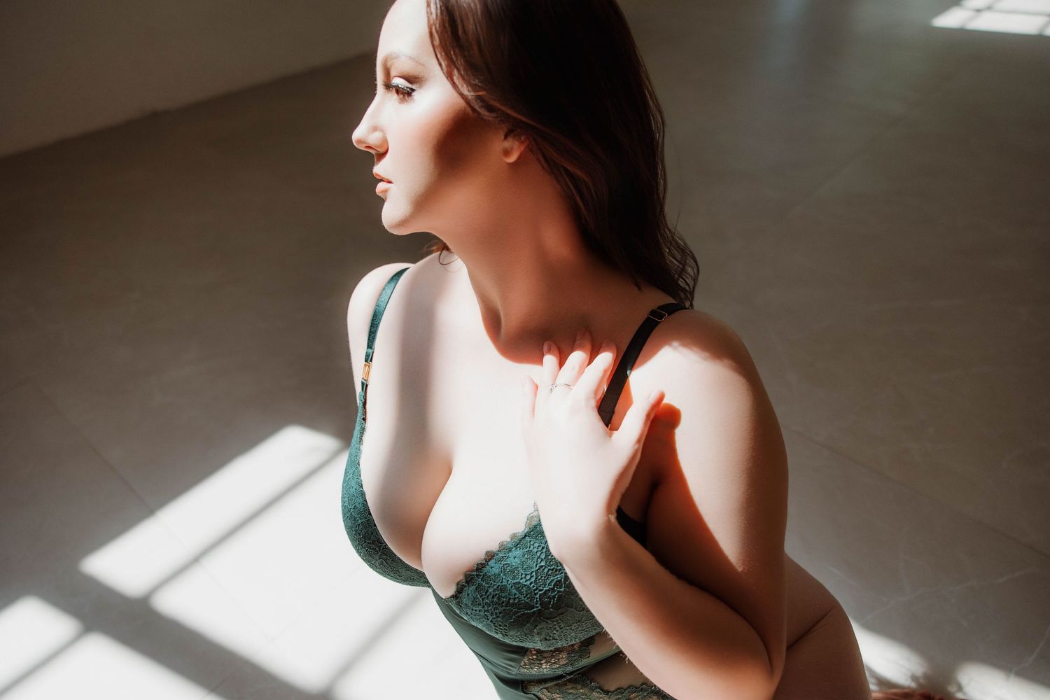Women posing in green lingerie illuminated by dramatic natural window light