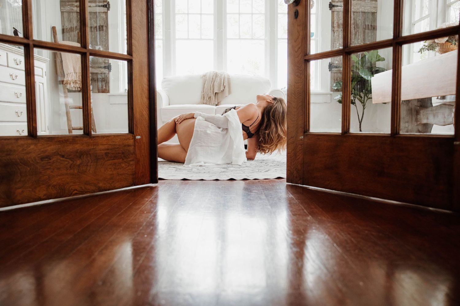 editorial session of a woman laying on the floor durning a boudoir session in a home studio