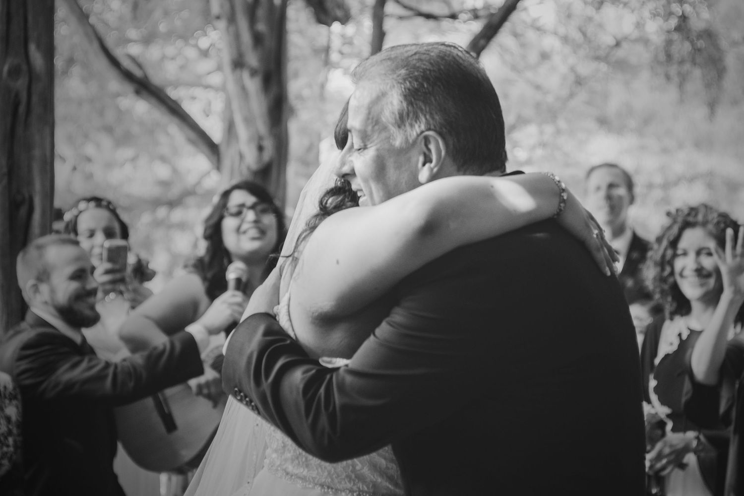Black and white photo of a bride and bride's father embracing during their daddy-daughter dance.