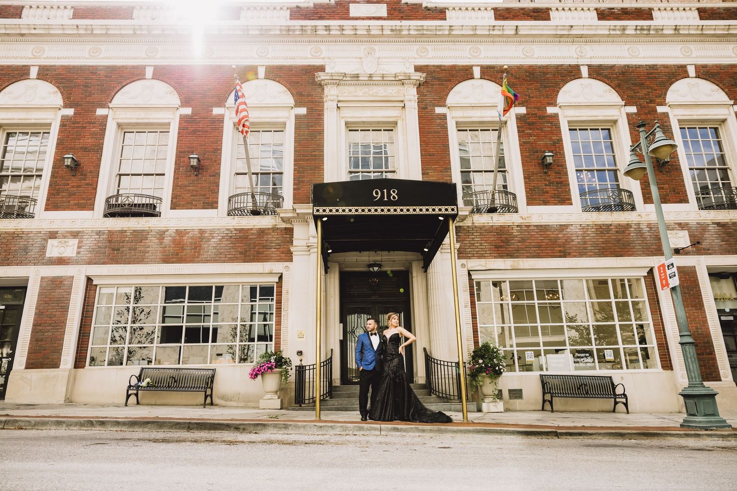 Bride and groom posing outside historic brick building entrance numbered 918 on their wedding evening.