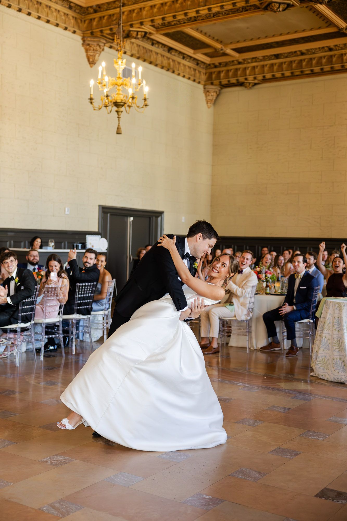 Bride and groom sharing a romantic dip during their first dance at wedding reception.
