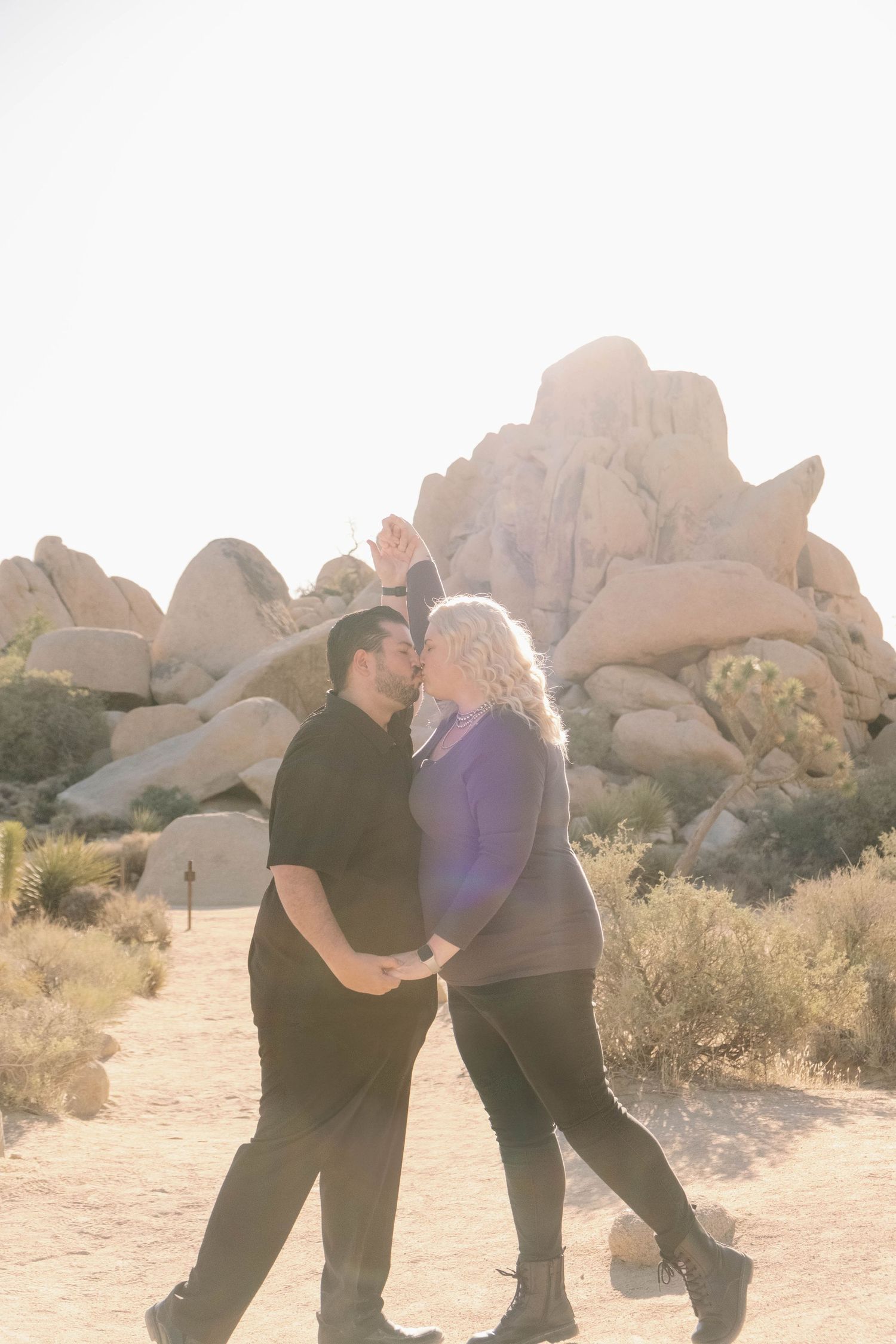 Couple shares a kiss at sunrise in Joshua Tree National Park.