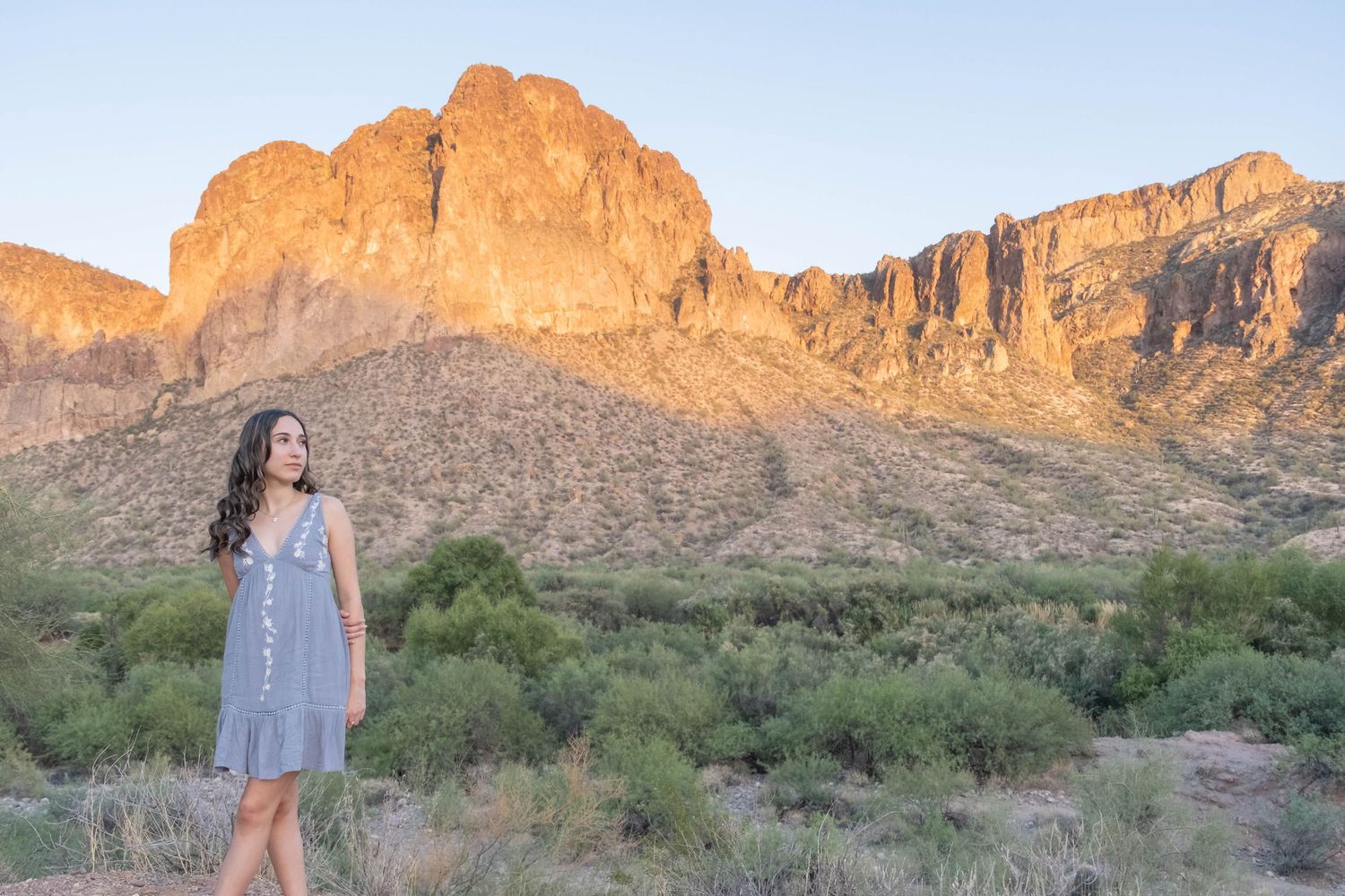 Majestic desert cliffs rise above the desert landscape at sunset.