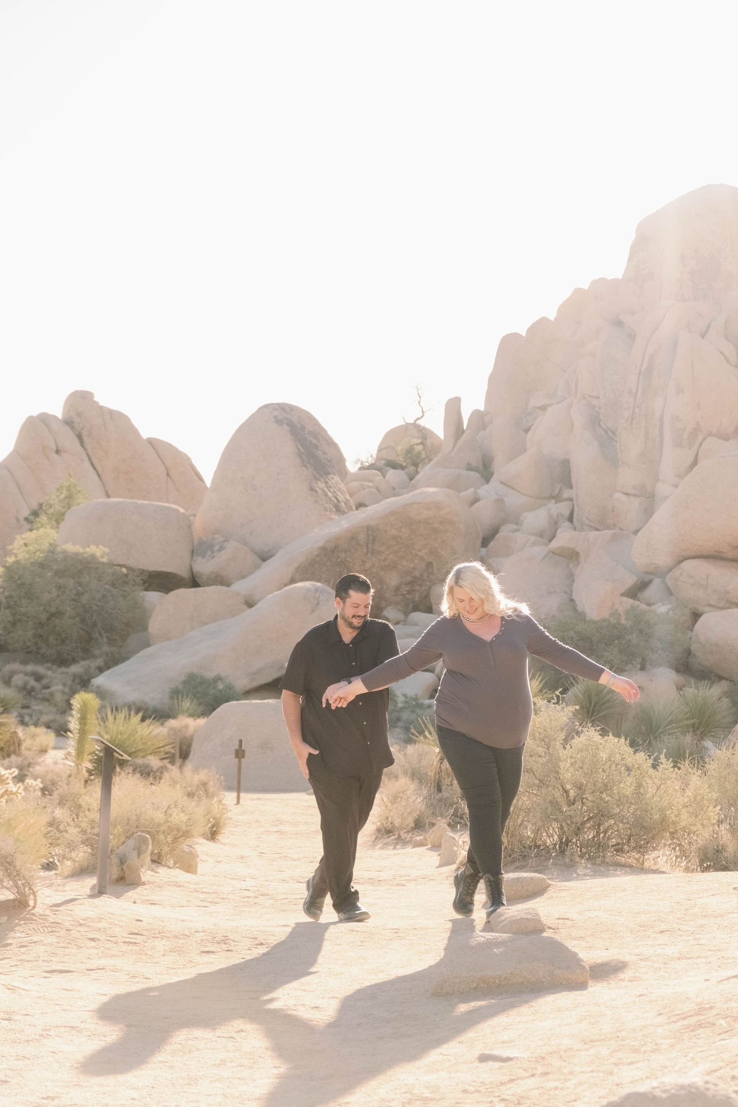 Couple laughing together during a sunrise couples engagement session in Joshua Tree National Park.
