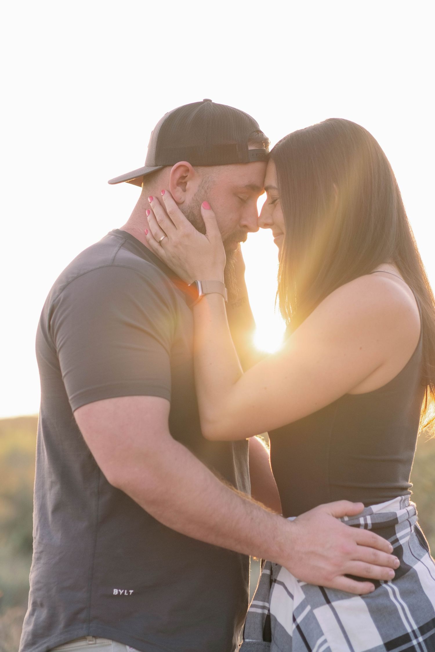 Intimate couple photography session showing passionate embraces against golden sunlight.