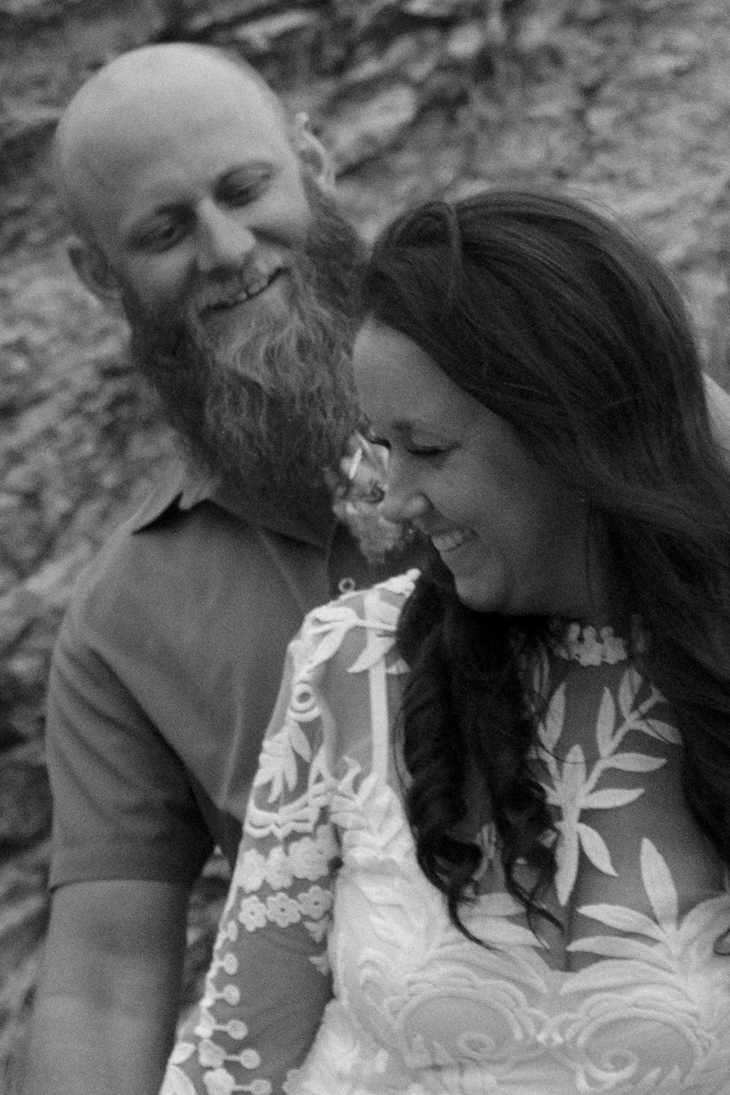 A joyful black and white portrait of a couple laughing together during their elopement.