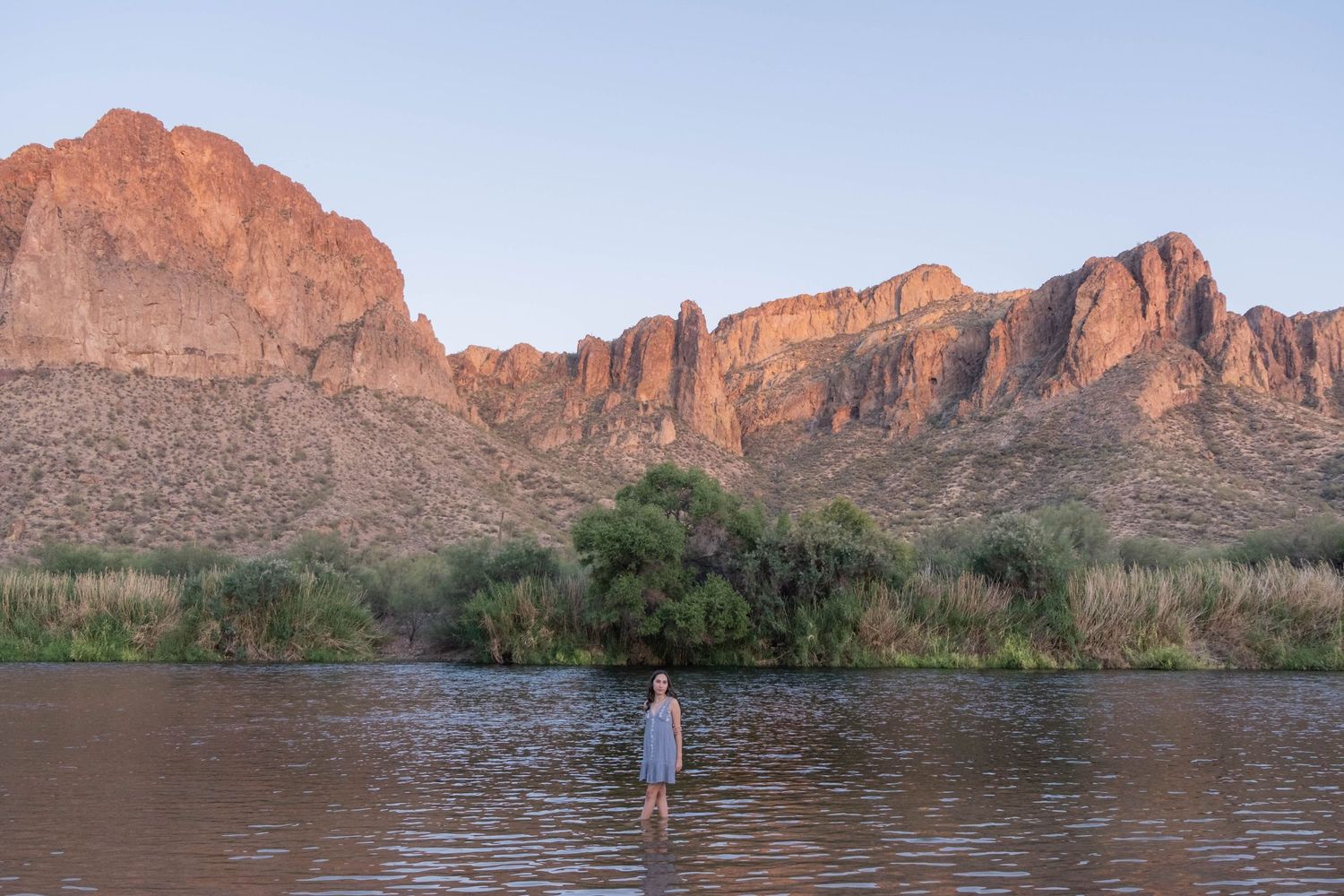 Desert mountain landscape with water and natural scenery at golden hour.