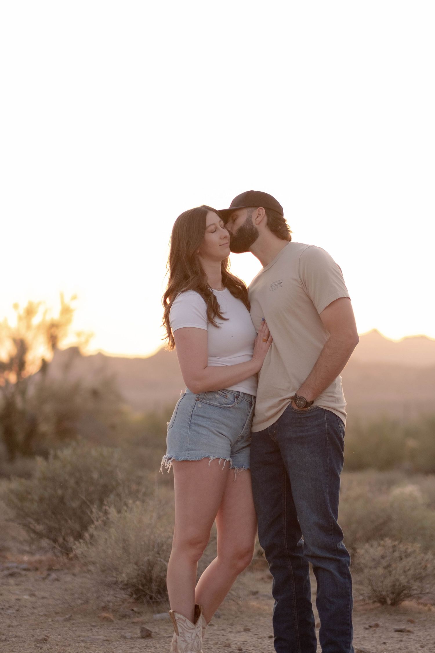A romantic sunset moment between a couple in the desert landscape.