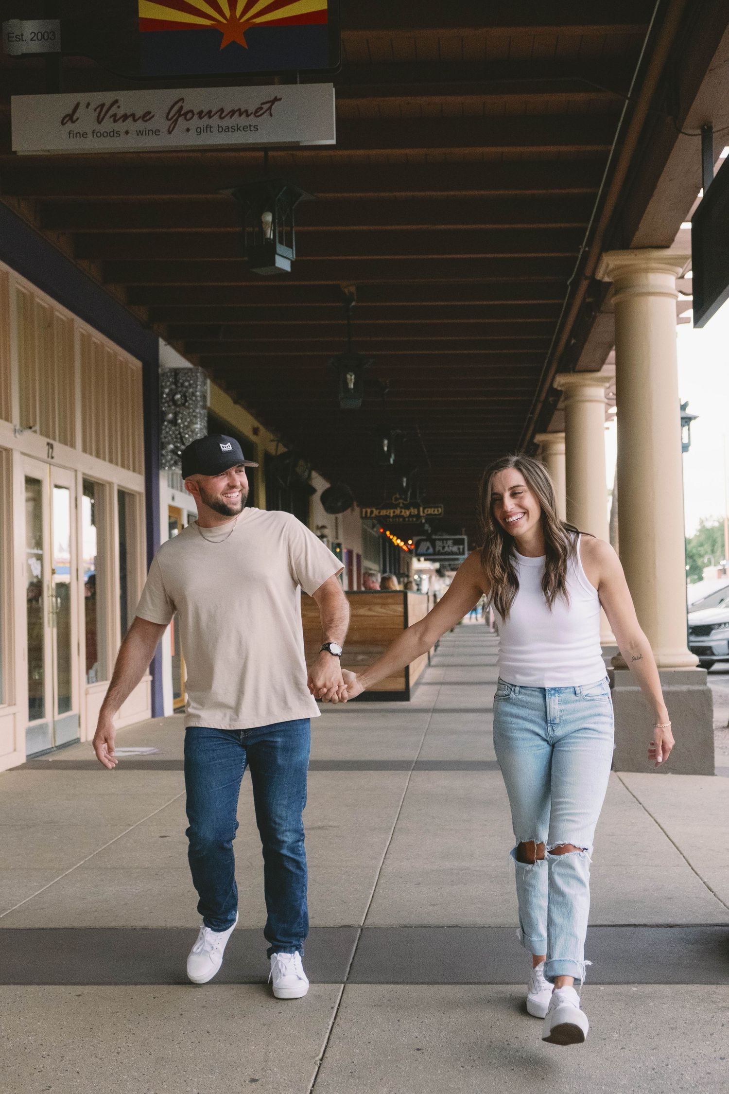 Couple walking under covered walkway during couples engagement session.