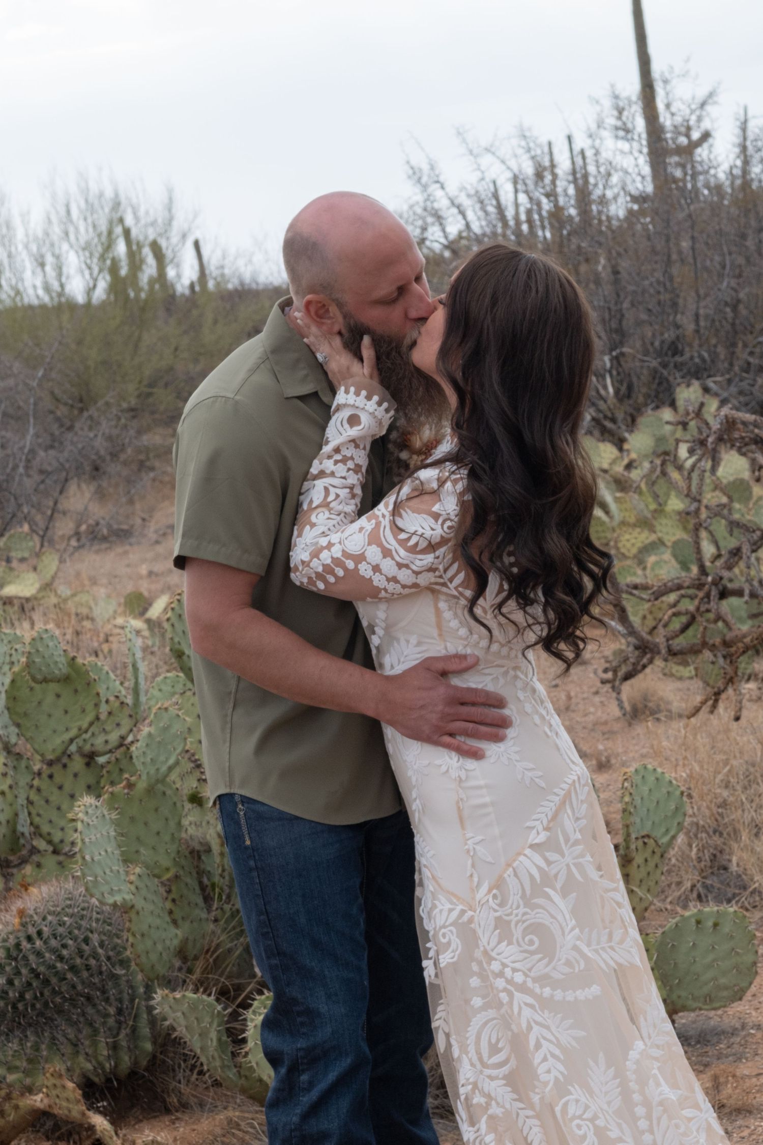 A romantic desert engagement portrait with natural cactus and brush in a rustic southwestern landscape for an elopement.