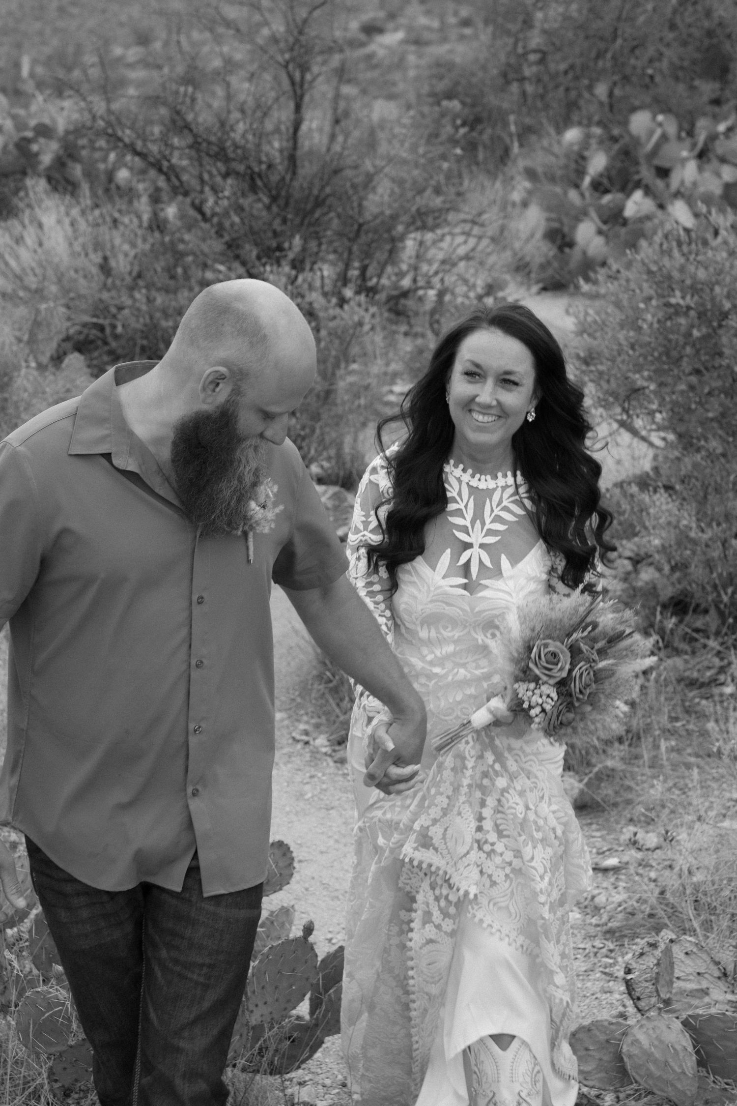 An eloping couple shares tender moments together in a series of black and white outdoor engagement photos by rocky terrain.