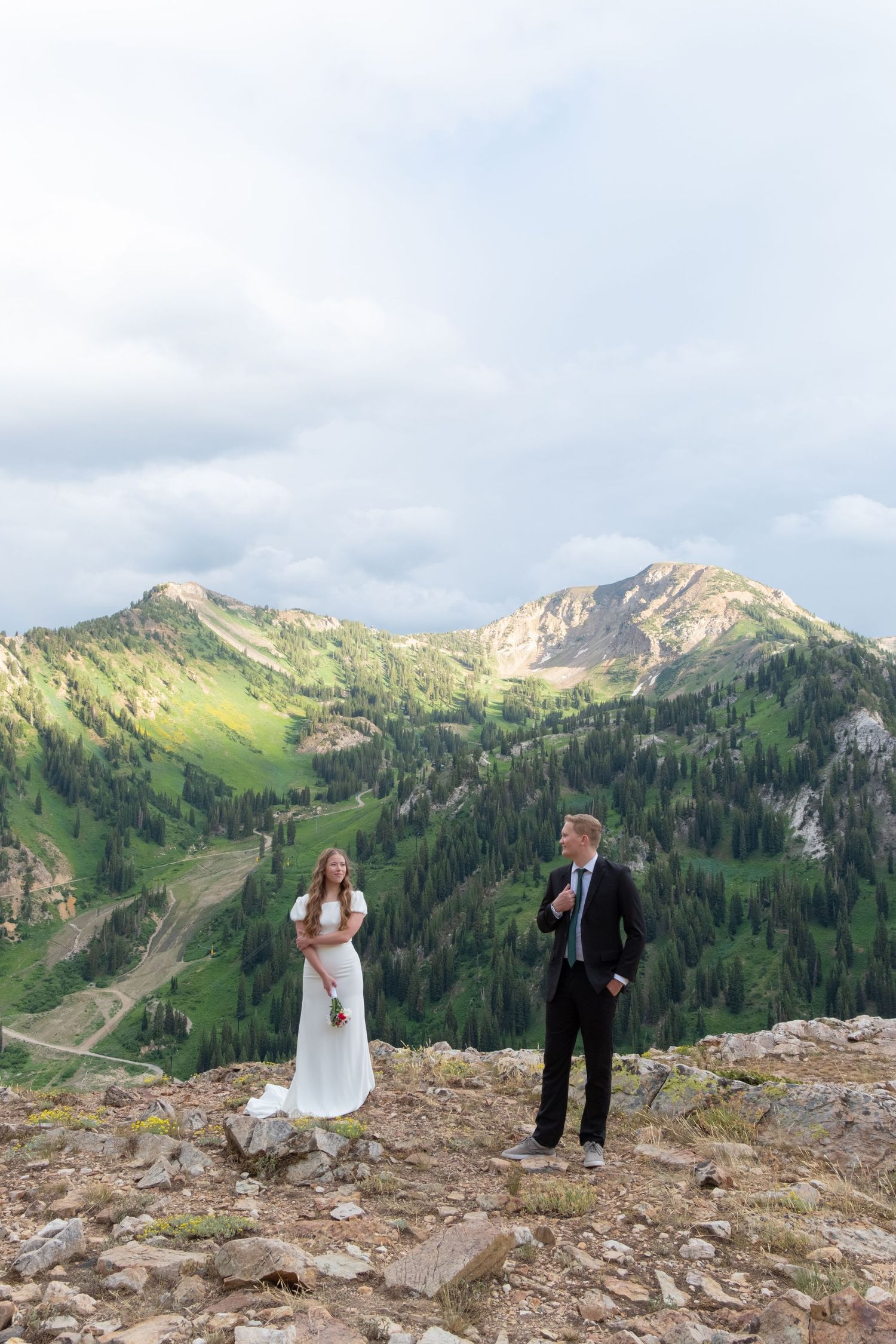 Mountain wedding photos taken at Snowbird Resort in Utah with majestic peaks and green slopes in summer.