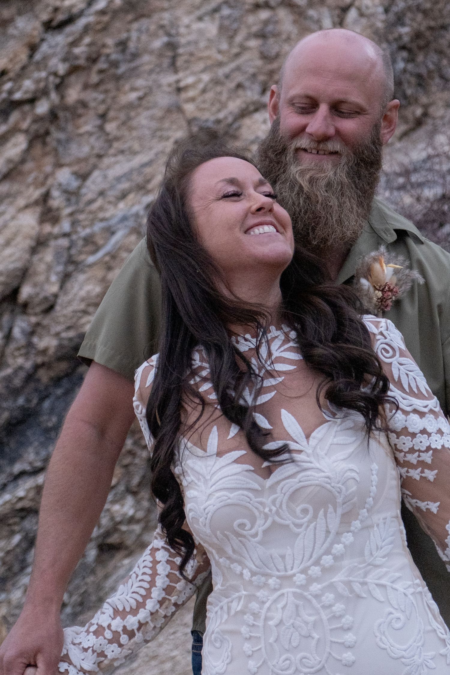 A couple shares an intimate embrace against a rocky backdrop during their elopement.