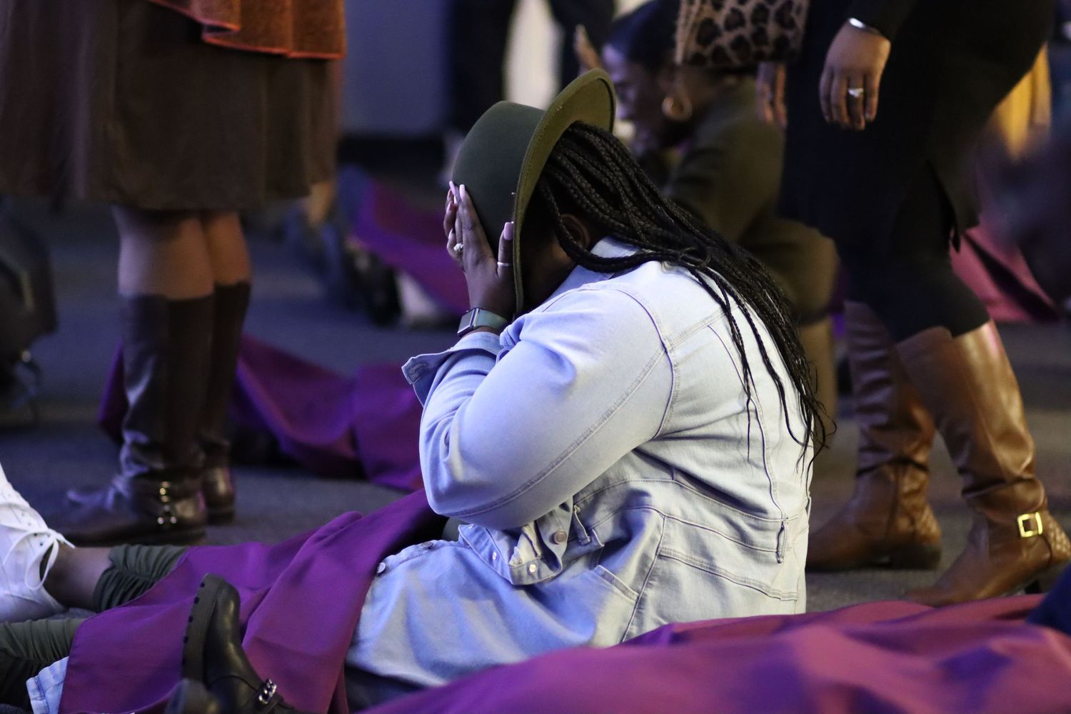 Person in white jacket sitting on purple cushions during an event.