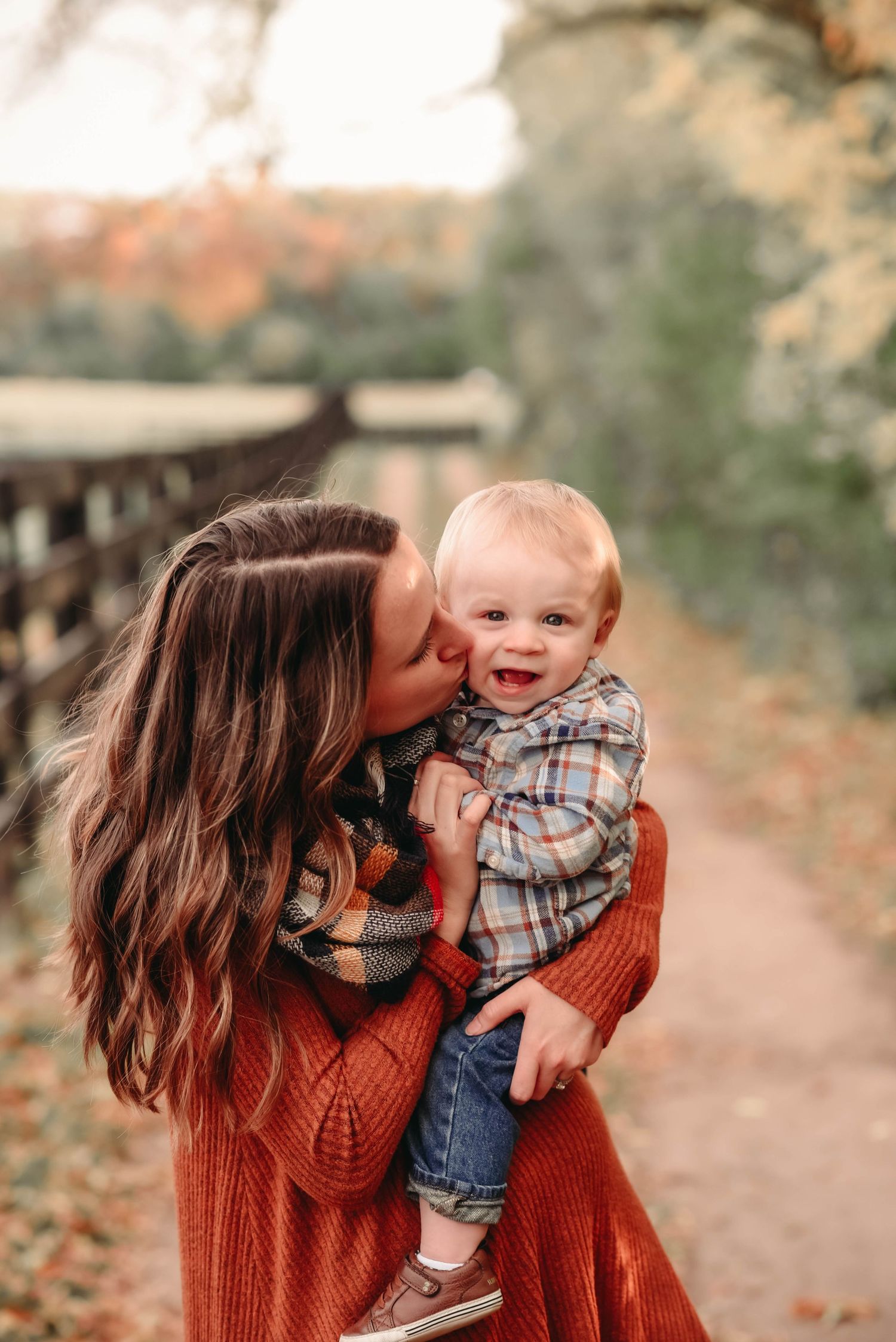 Heartwarming outdoor autumn photos showing tender family moments in warm fall colors.