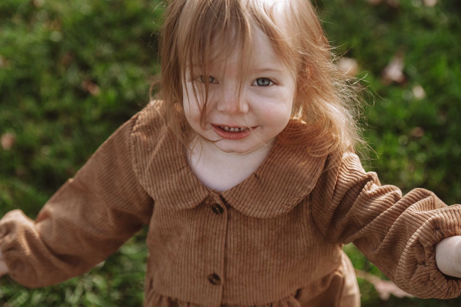 A sequence of photos shows a young child with red hair in a brown sweater making various playful expressions.