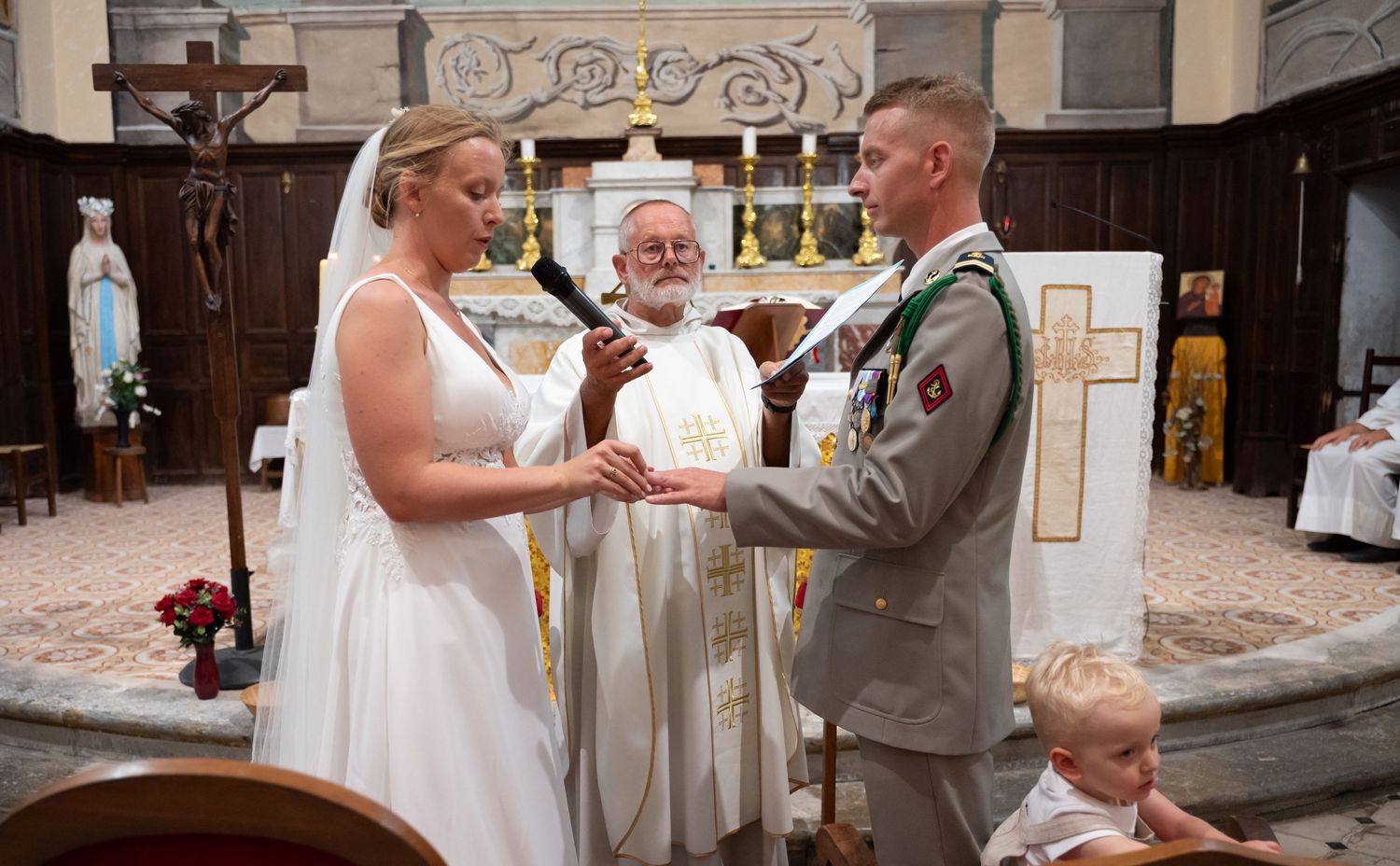 Wedding ceremony in progress inside traditional church with ornate architectural details.