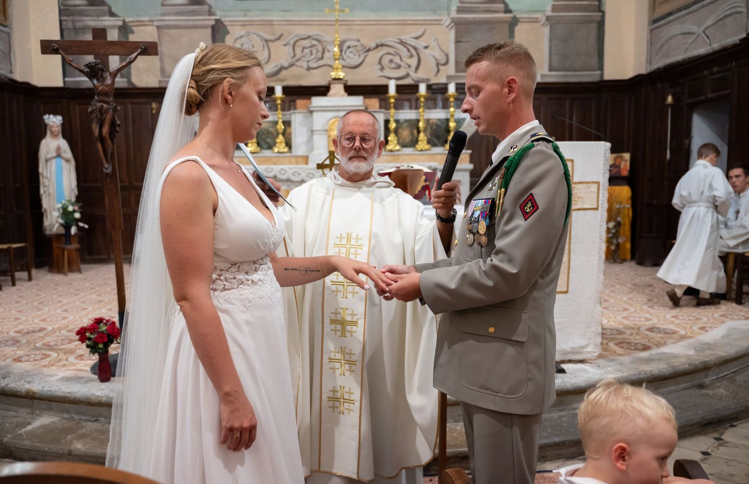 Wedding ceremony taking place in ornate church with traditional decor and architecture.