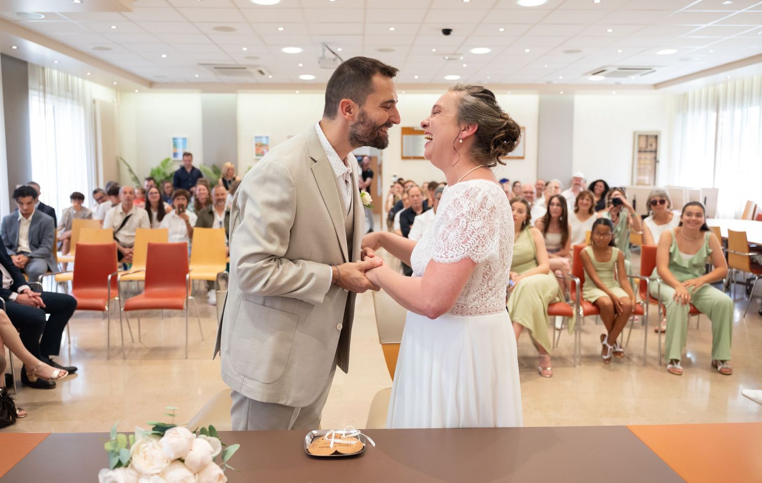 Couple sharing a tender moment during their wedding ceremony as guests look on.