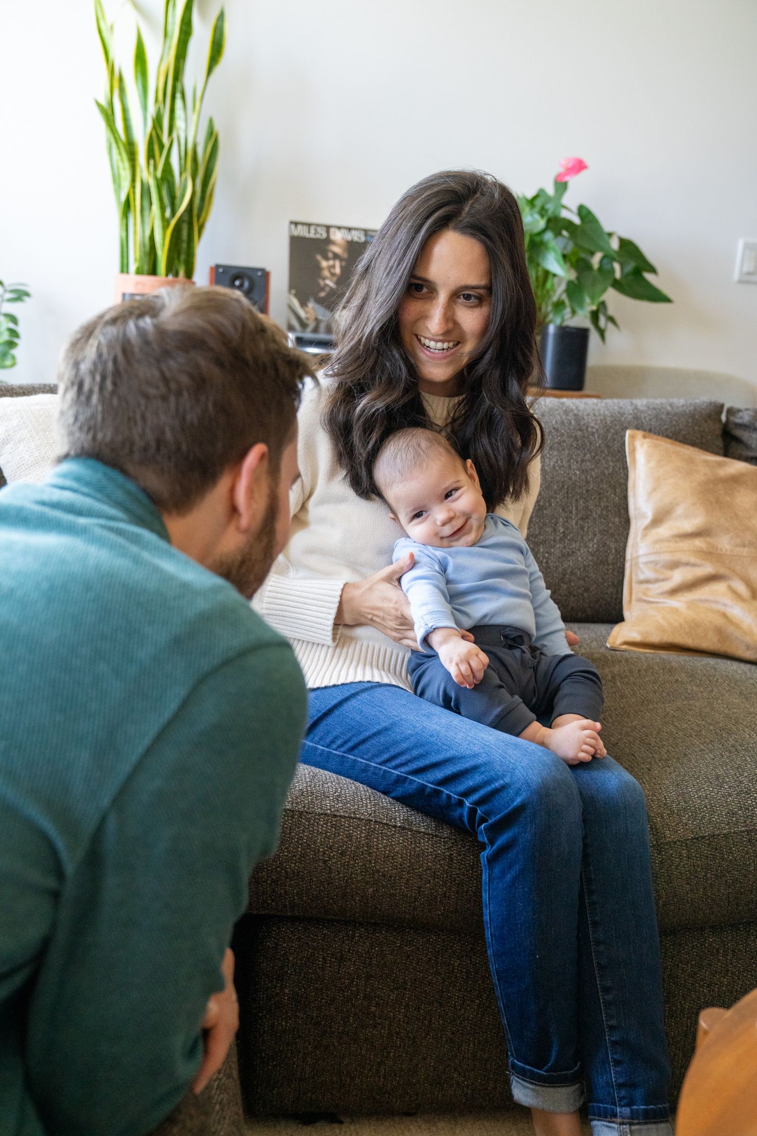 A series of playful moments captured on a brown couch with house plants visible in the background.
