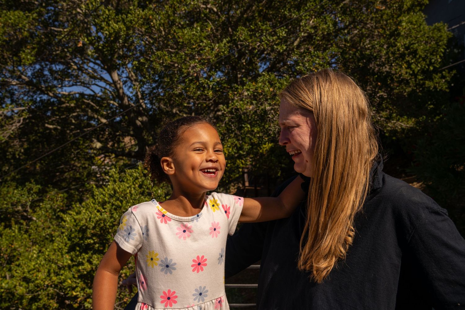 A series of candid outdoor family photos taken in a sunny garden setting with natural greenery in the background.