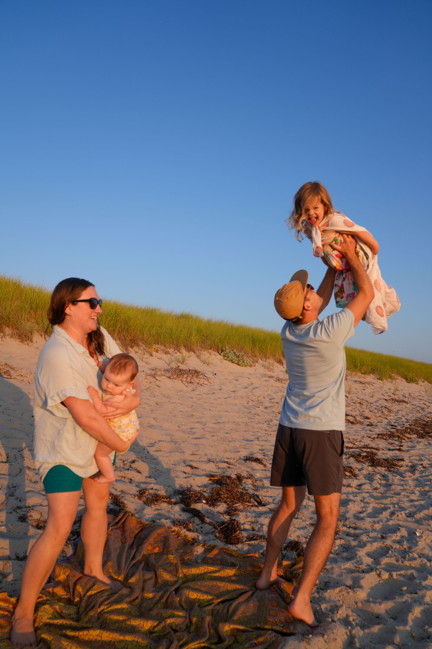 A sequence of playful moments captured on a sandy beach during golden hour against a bright blue sky.