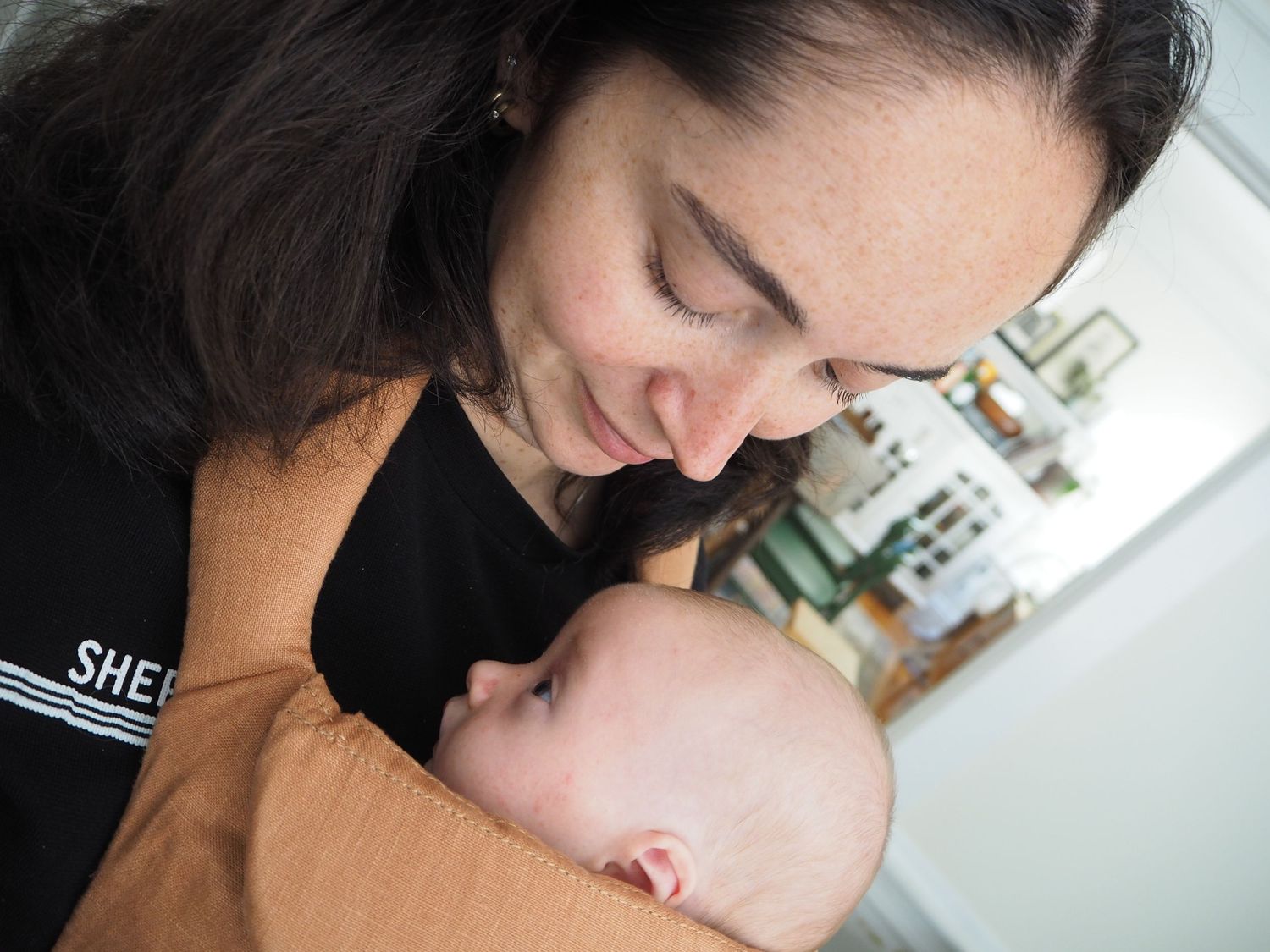 Tender moment captured in soft indoor lighting with natural expressions.