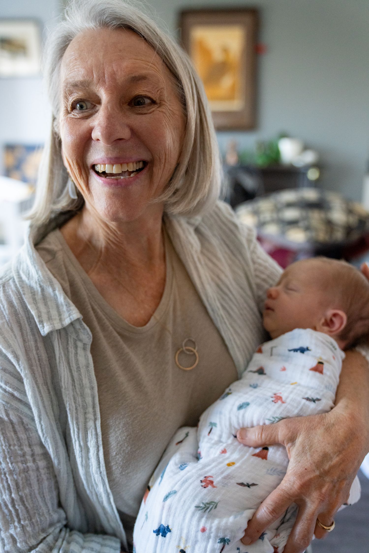 A tender moment captured as a baby in white sleepwear is cradled and comforted in loving arms.