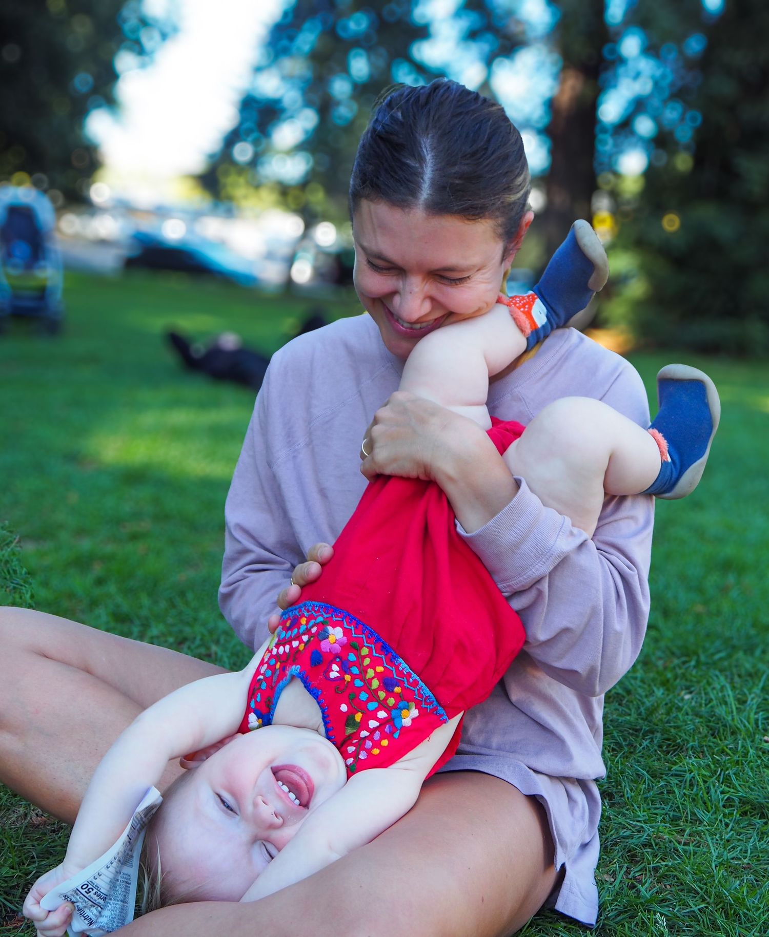 A tender moment shared outdoors on grass in casual clothing.