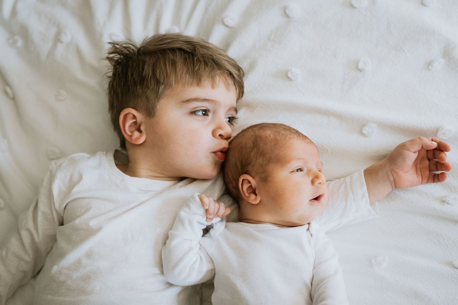 big brother kissing newborn’s head