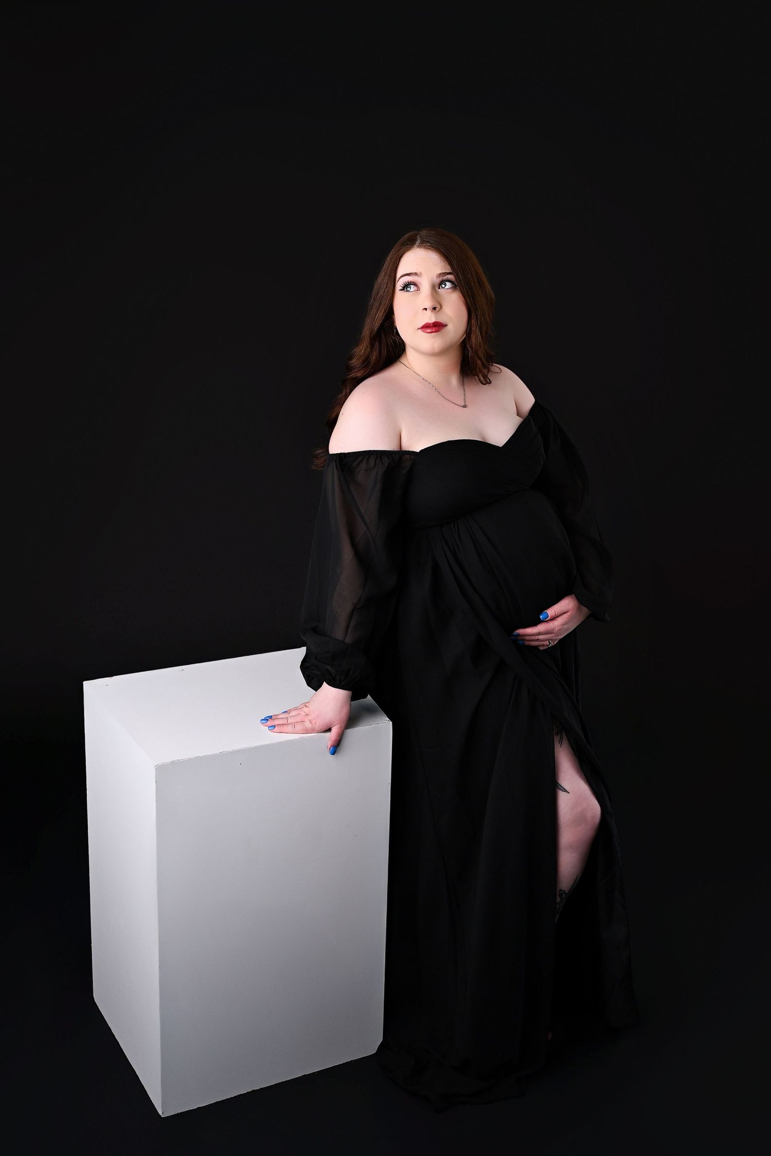 Glamorous and luxurious black on black maternity session with lighting from above. Giving off a sexy gothic feel